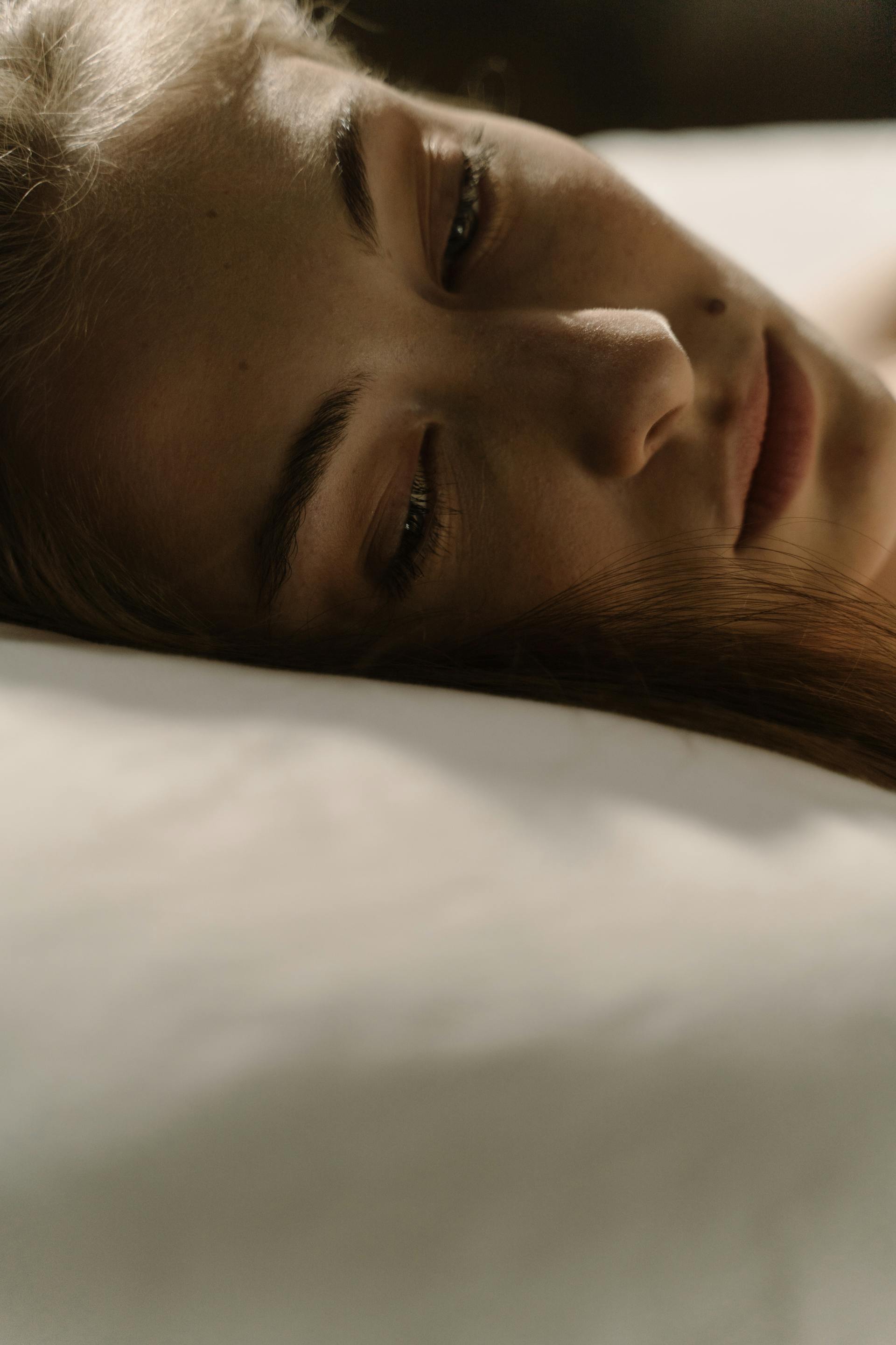 Una donna che giace sveglia a letto | Fonte: Pexels