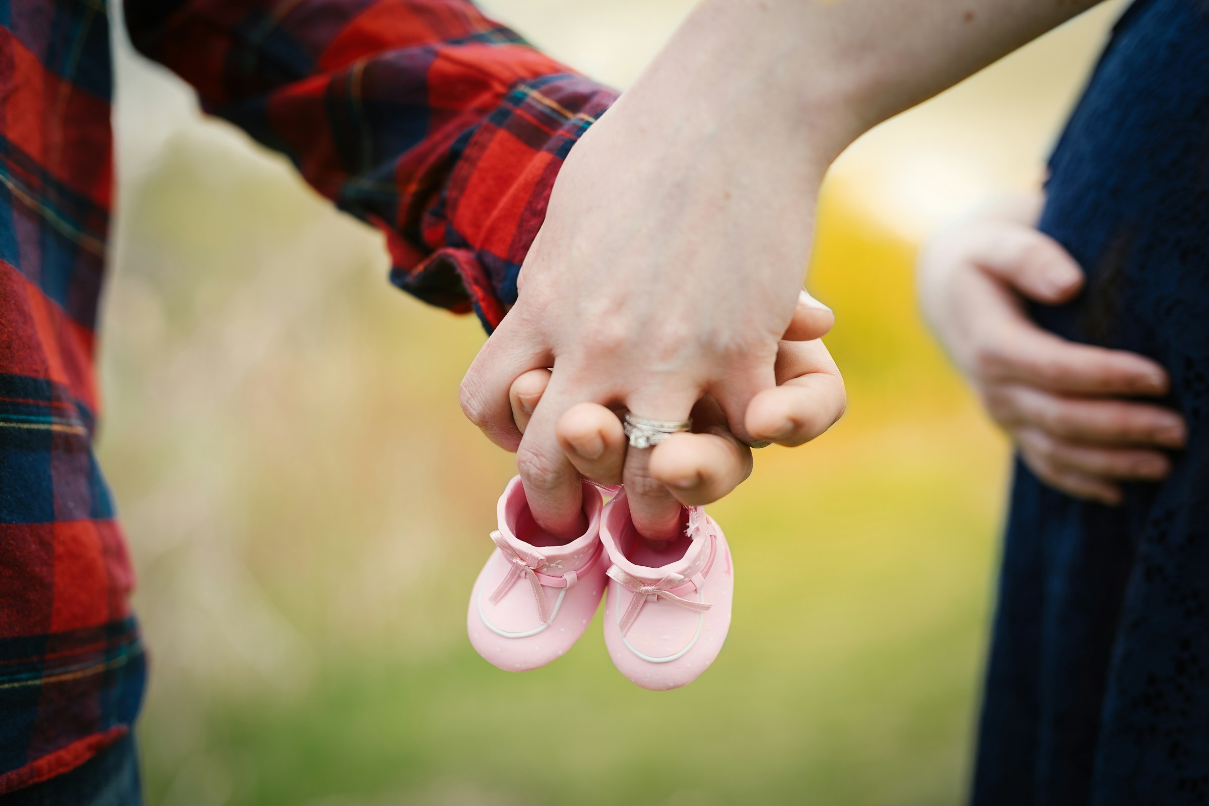 Una pareja de embarazadas sosteniendo un par de zapatitos rosas | Fuente: Unsplash