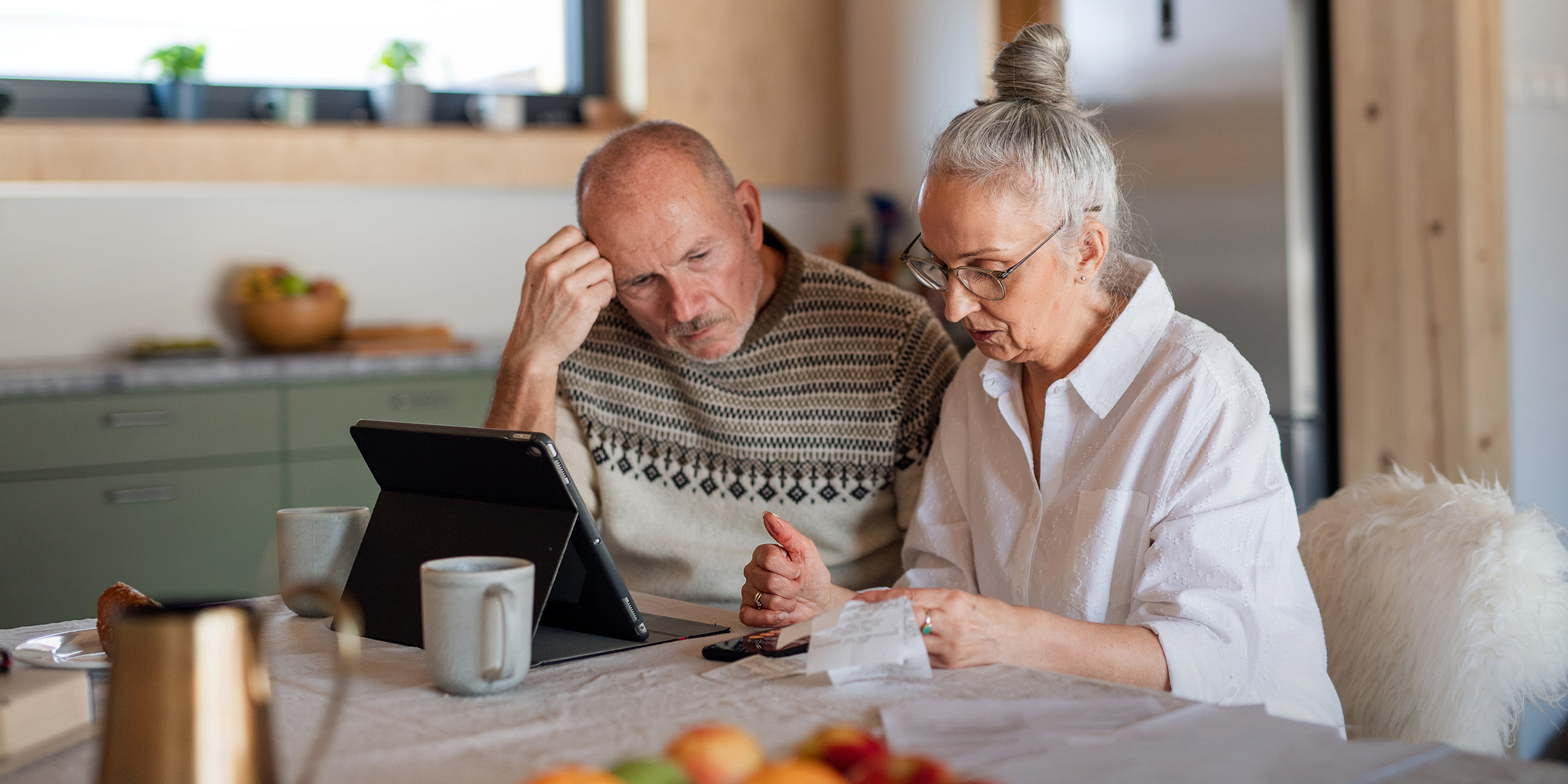 Una pareja de ancianos mirando una tableta | Fuente: Getty Images