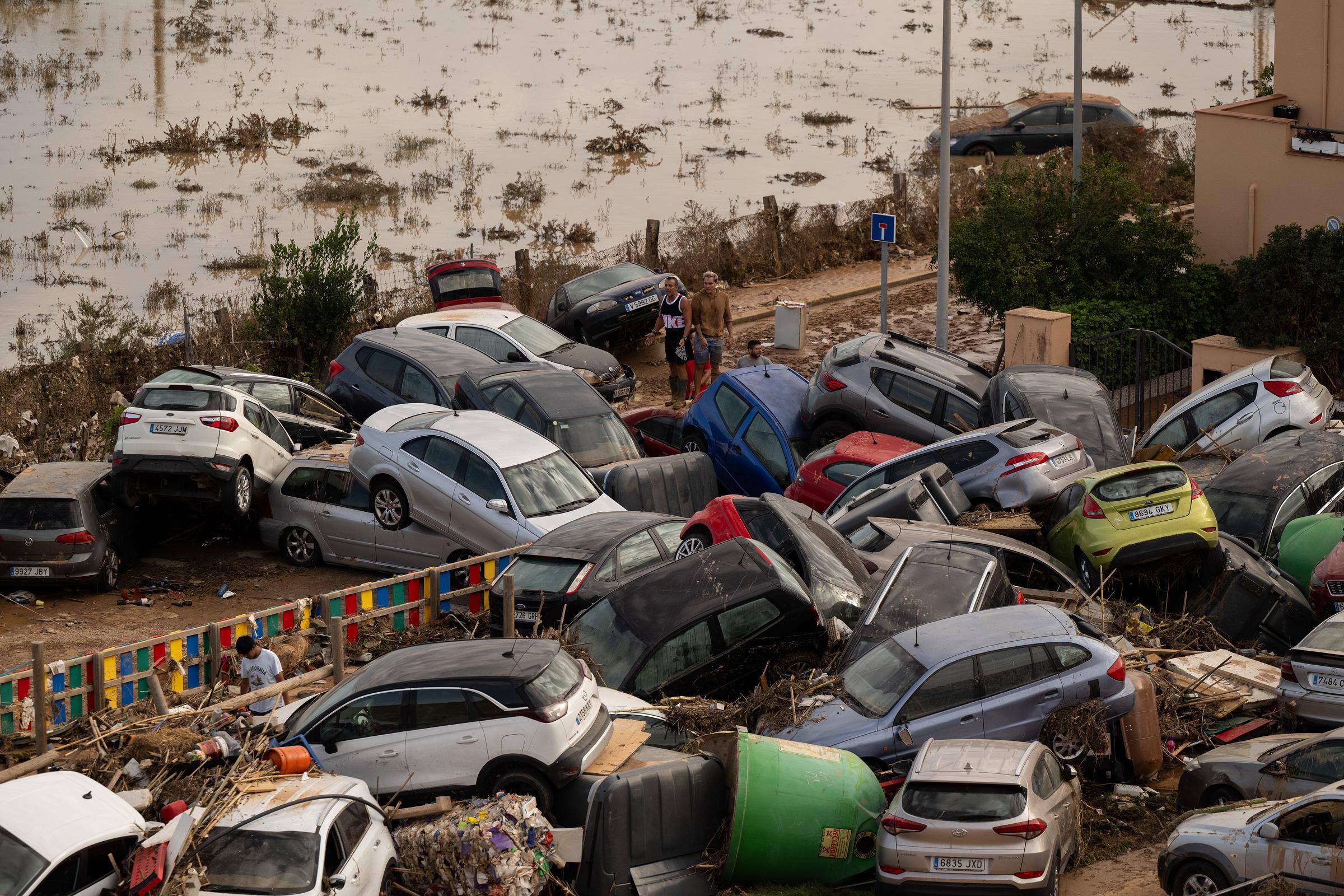 La gente se para encima de los coches destruidos después de que las inundaciones afectaran a gran parte del país el 31 de octubre de 2024 en el municipio de La Torre de Valencia, España | Fuente: Getty Images