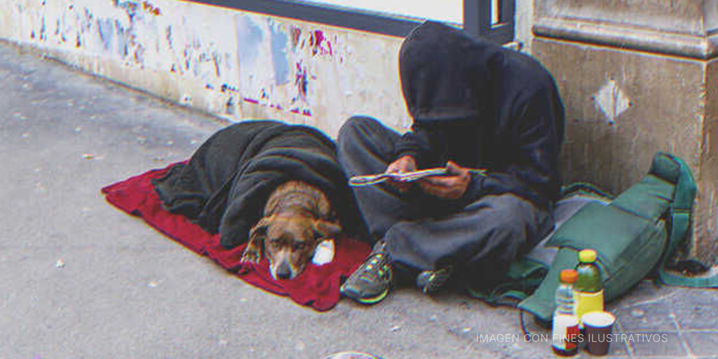Hombre sin hogar sentado en la calle con un perro. | Foto: Shutterstock