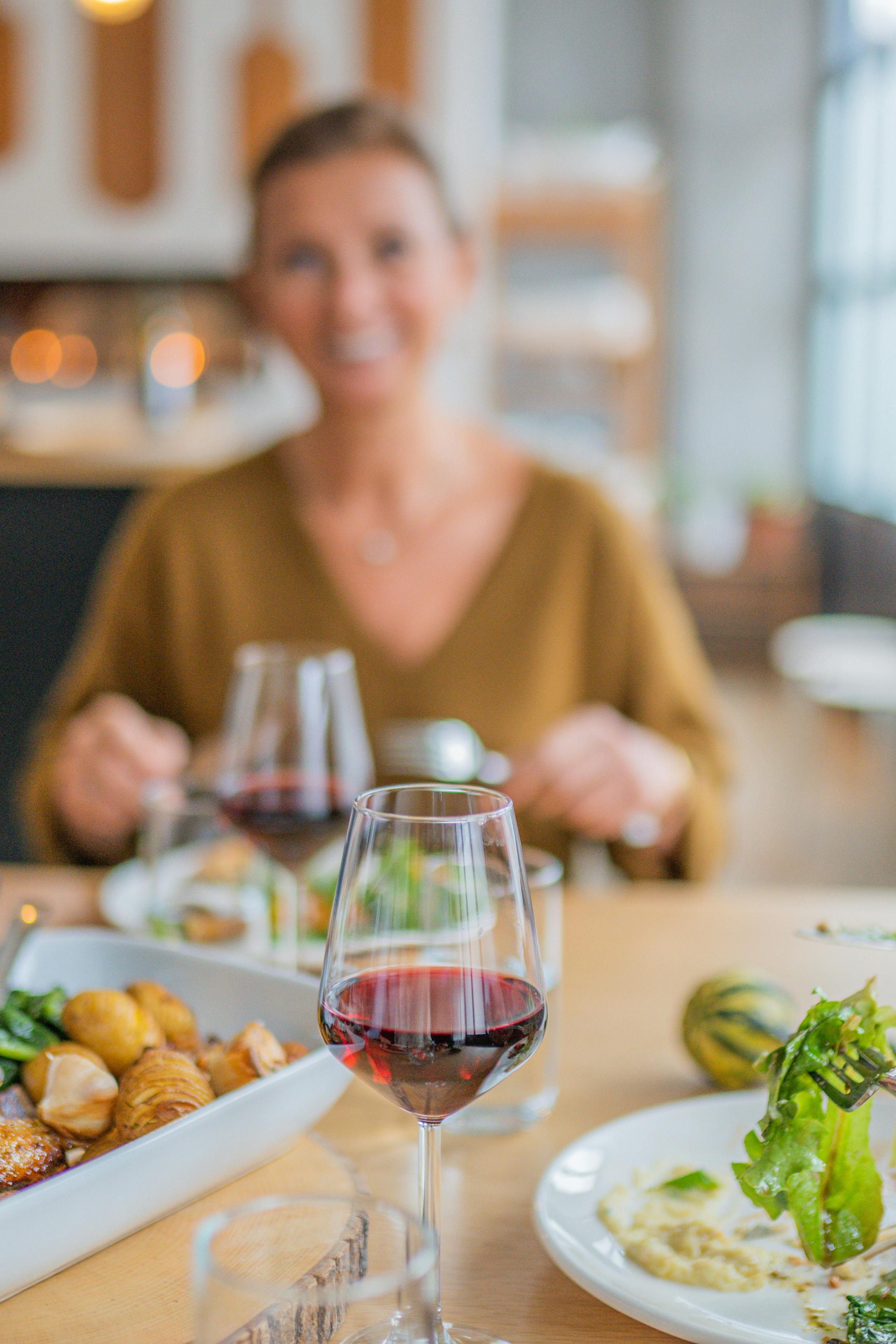 Una foto sfocata di una donna che sorride mentre mangia | Fonte: Pexels