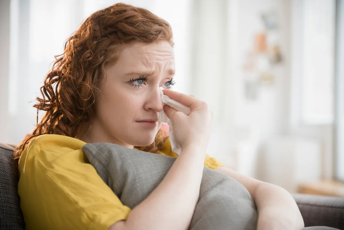 Una mujer llorando agarrada a una almohada | Fuente: Getty Images