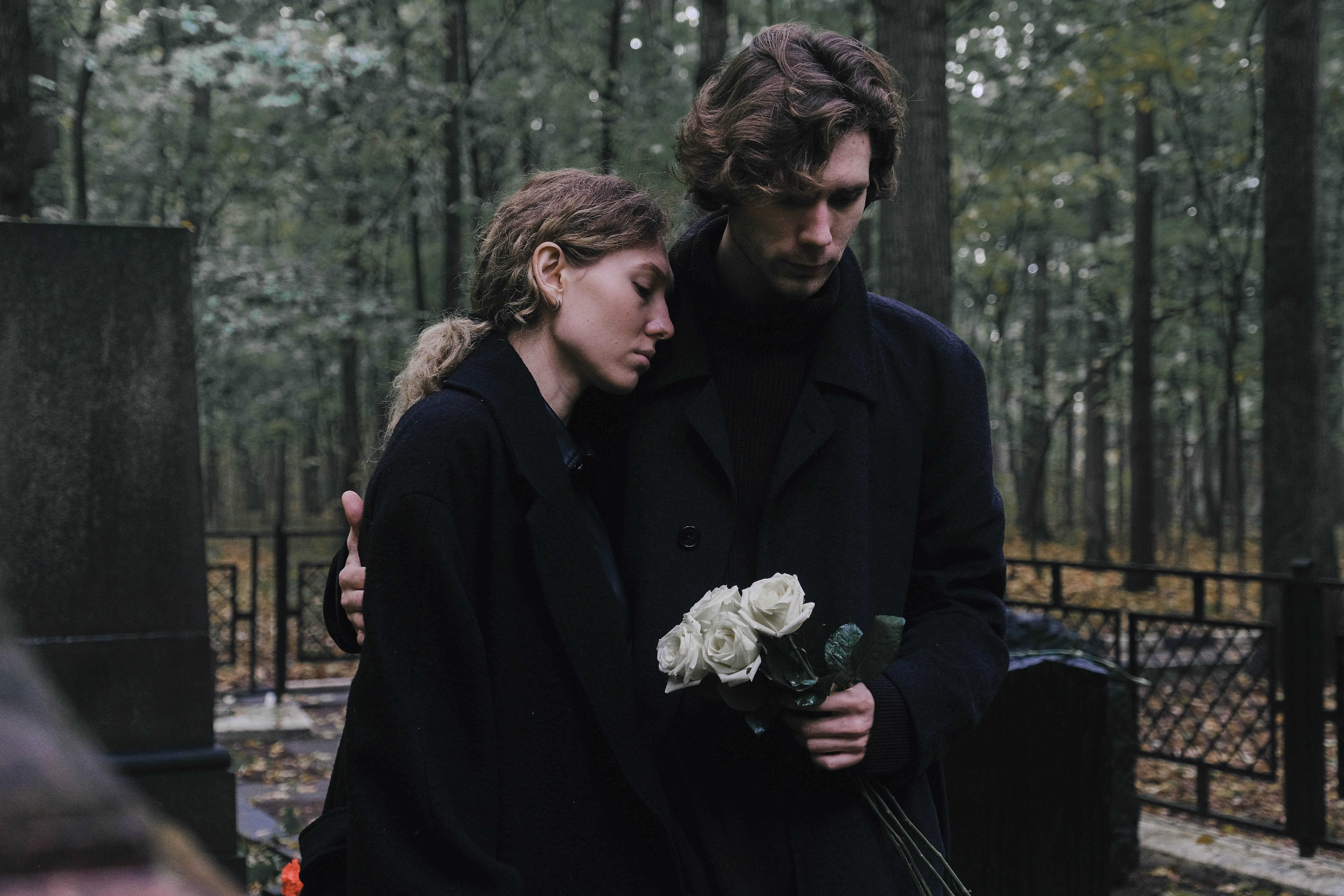 Pareja joven, hombre y mujer, de luto en el cementerio | Fuente: Getty Images