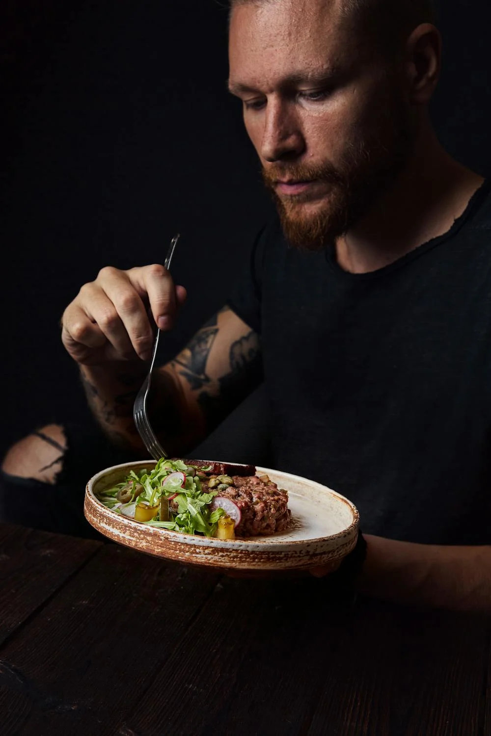 Un hombre comiendo carne con verduras | Fuente: Pexels