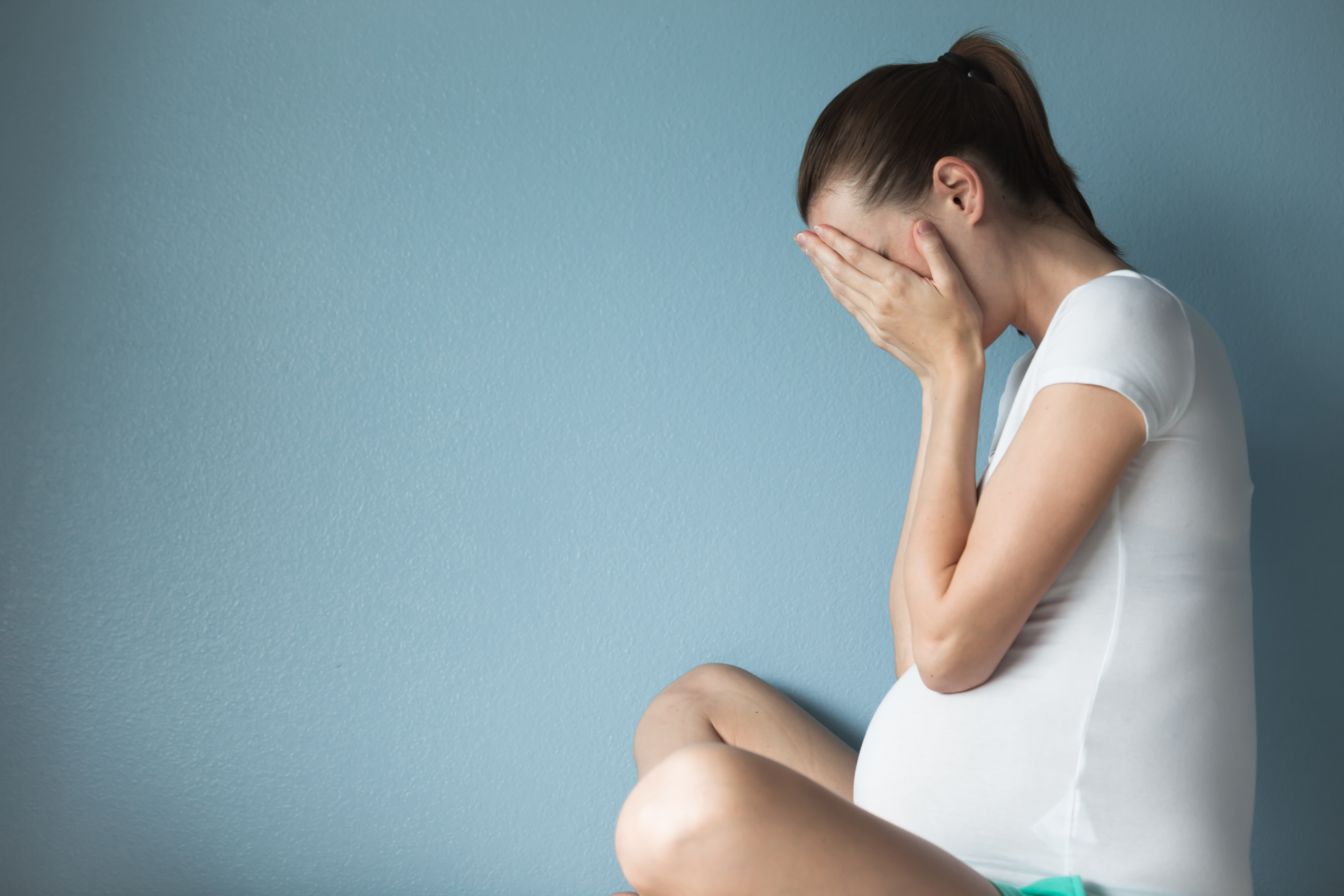 Una embarazada disgustada sujetándose el vientre | Fuente: Shutterstock