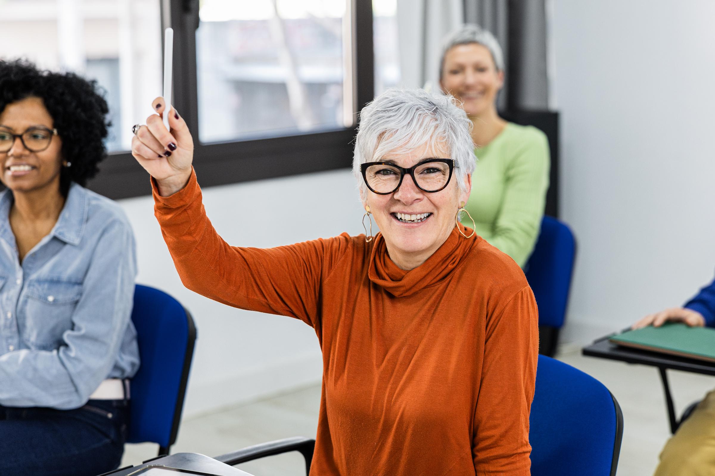 Una estudiante levanta la mano para hacer una pregunta | Fuente: Getty Images