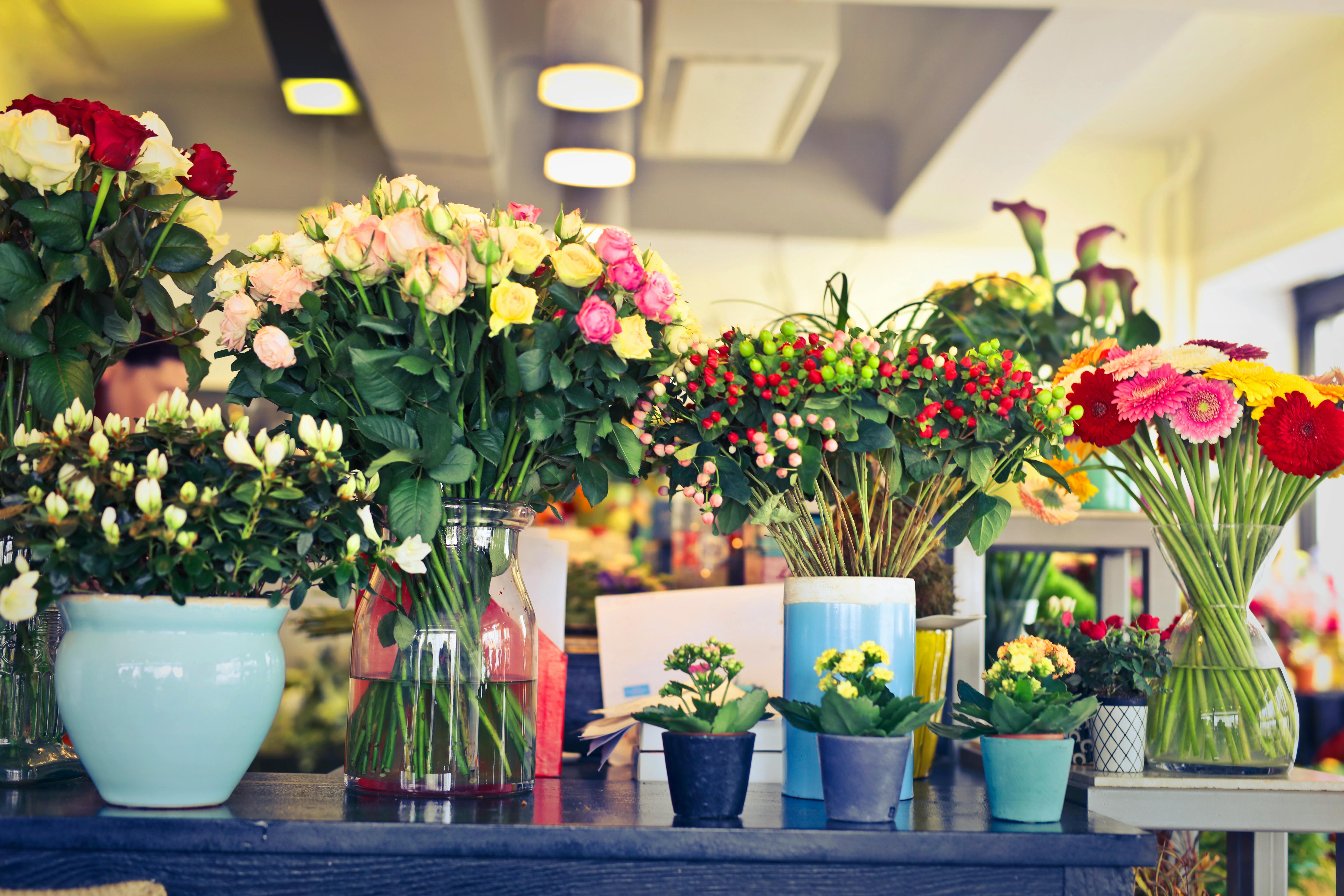 Una mesa llena de flores y jarrones | Fuente: Pexels