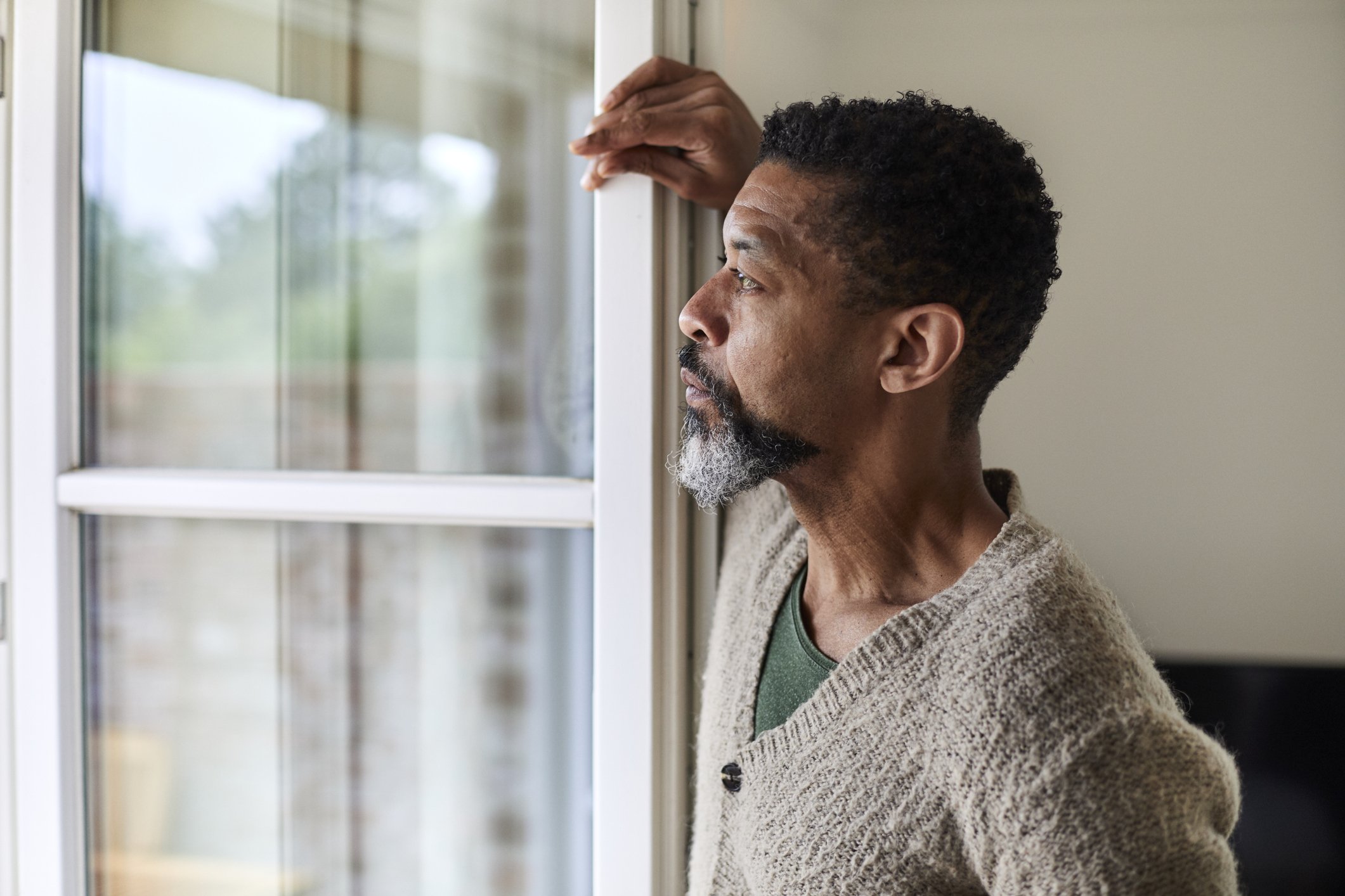 Un hombre preocupado mira por la ventana. | Foto: Getty Images