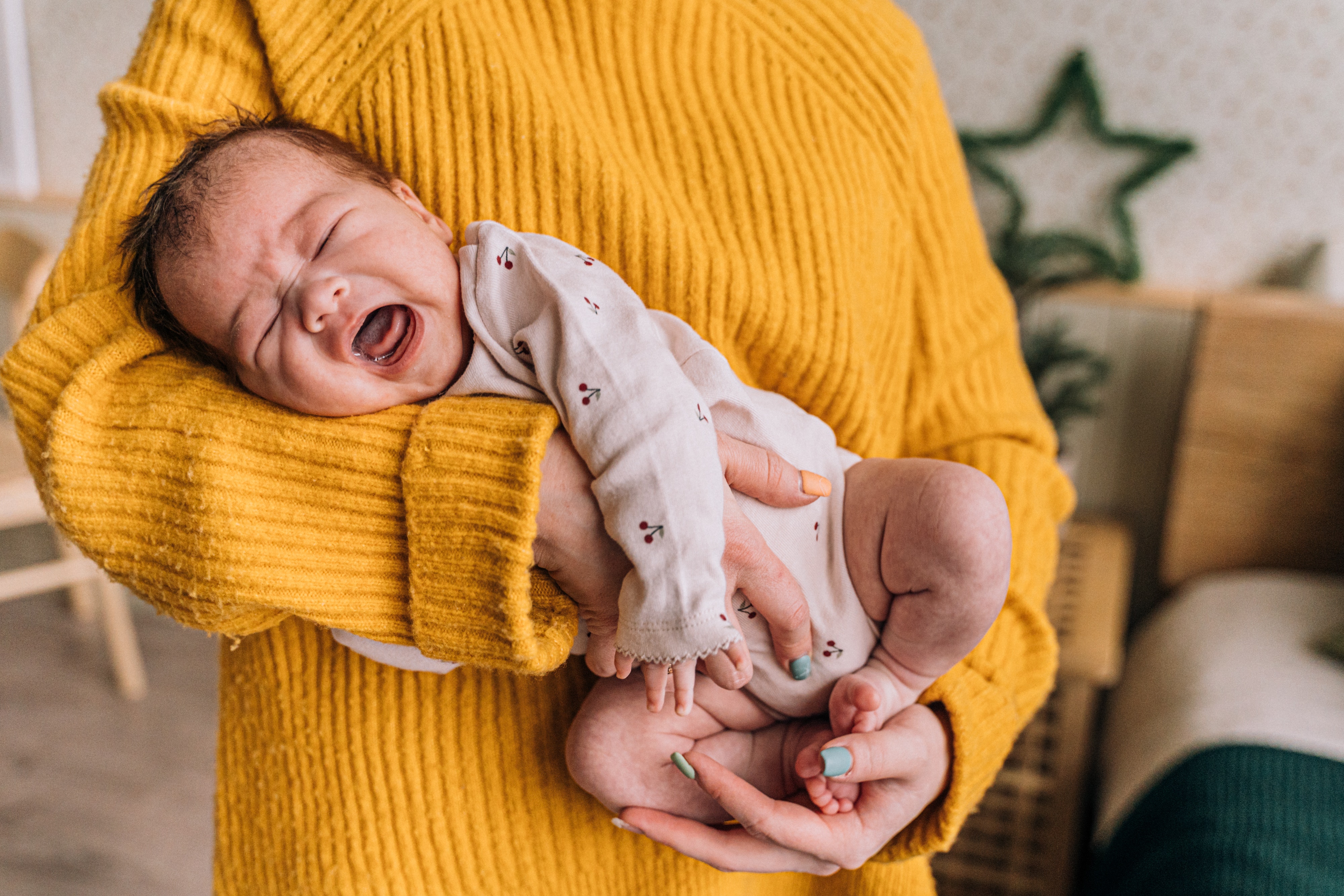 Una mujer acuna a un bebé que llora | Foto: Pexels