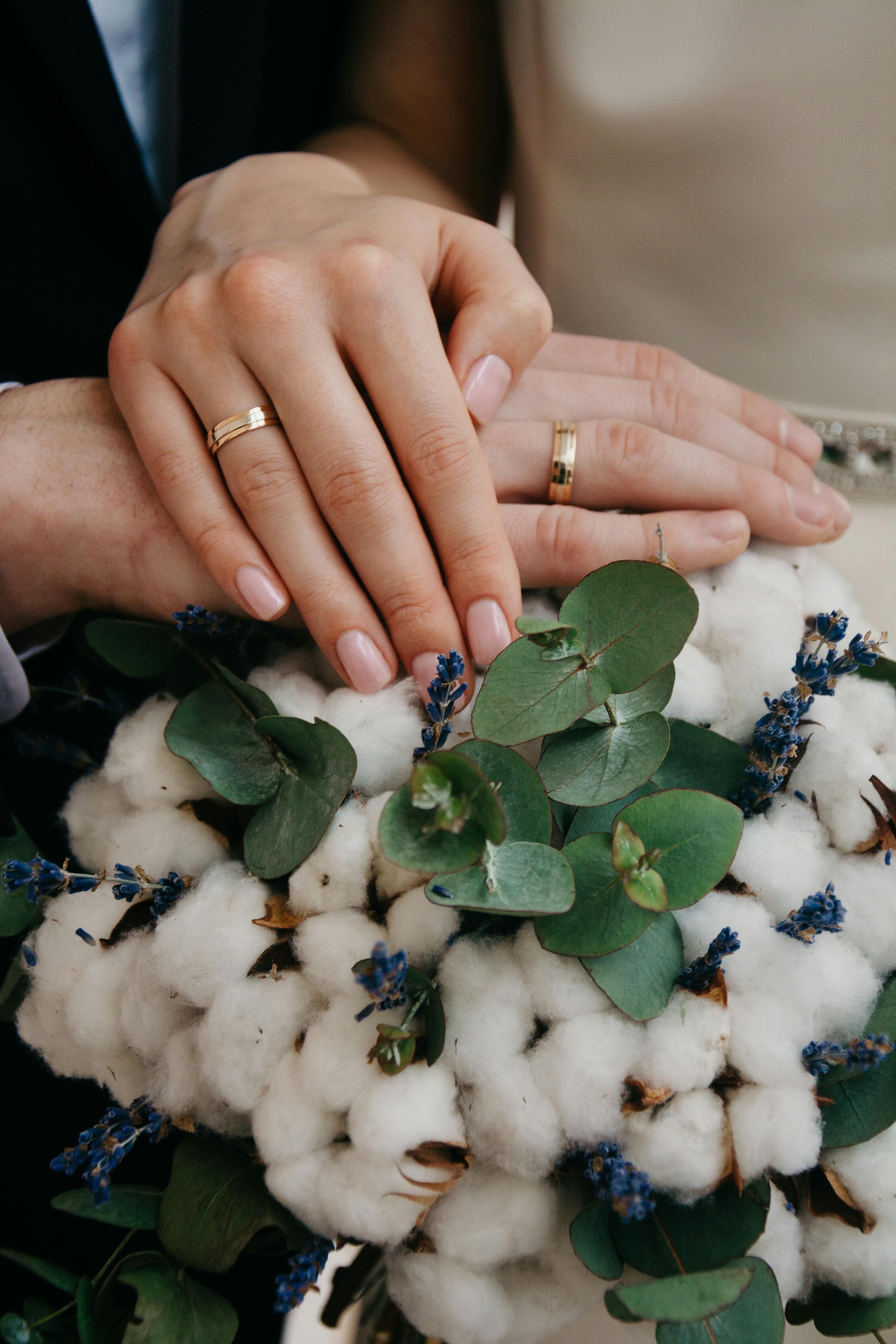 Sólo con fines ilustrativos. Una pareja mostrando su ramo de novia y sus anillos | Fuente: Pexels
