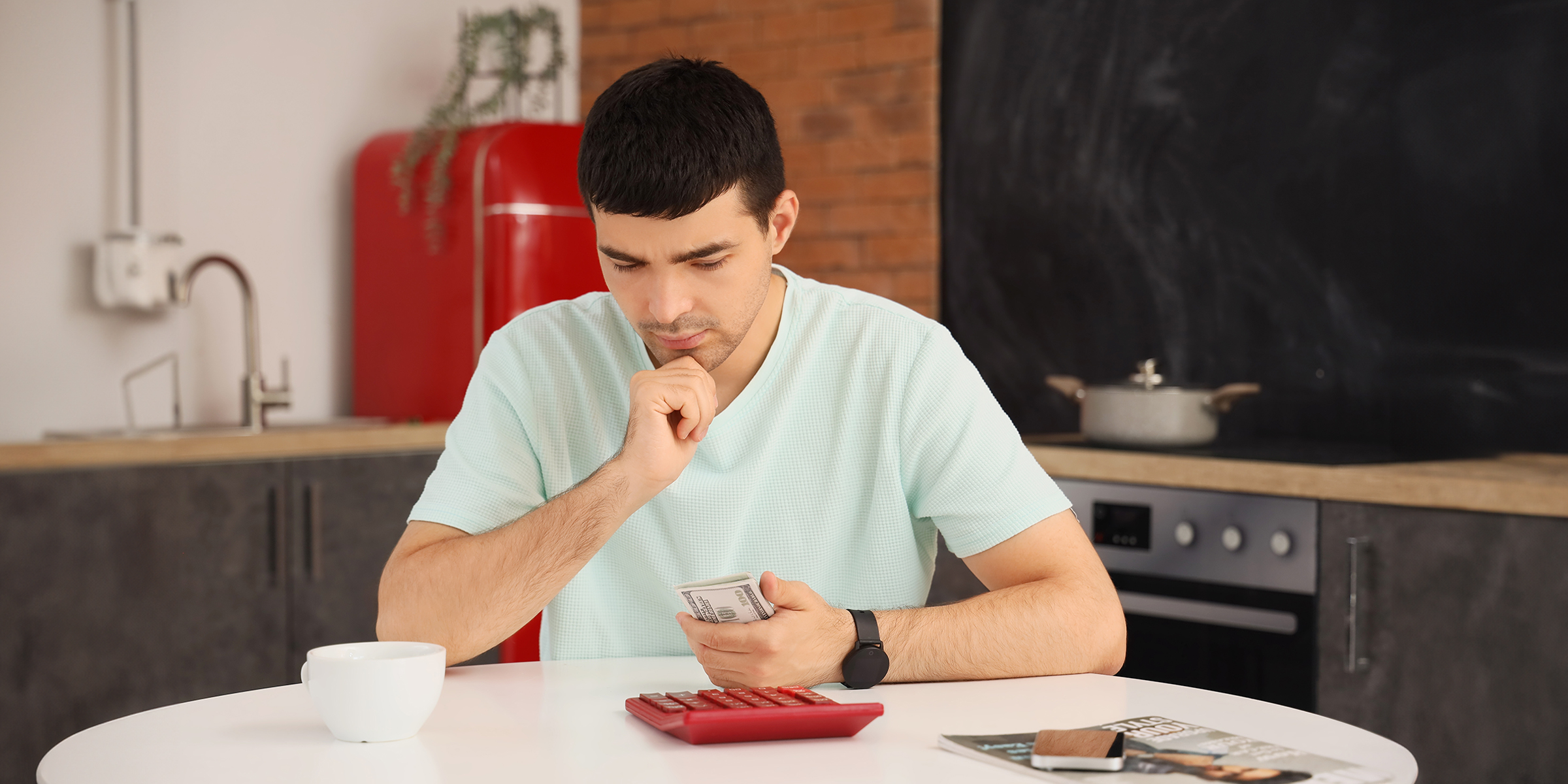 Hombre con dinero en mano y una calculadora | Fuente: Shutterstock