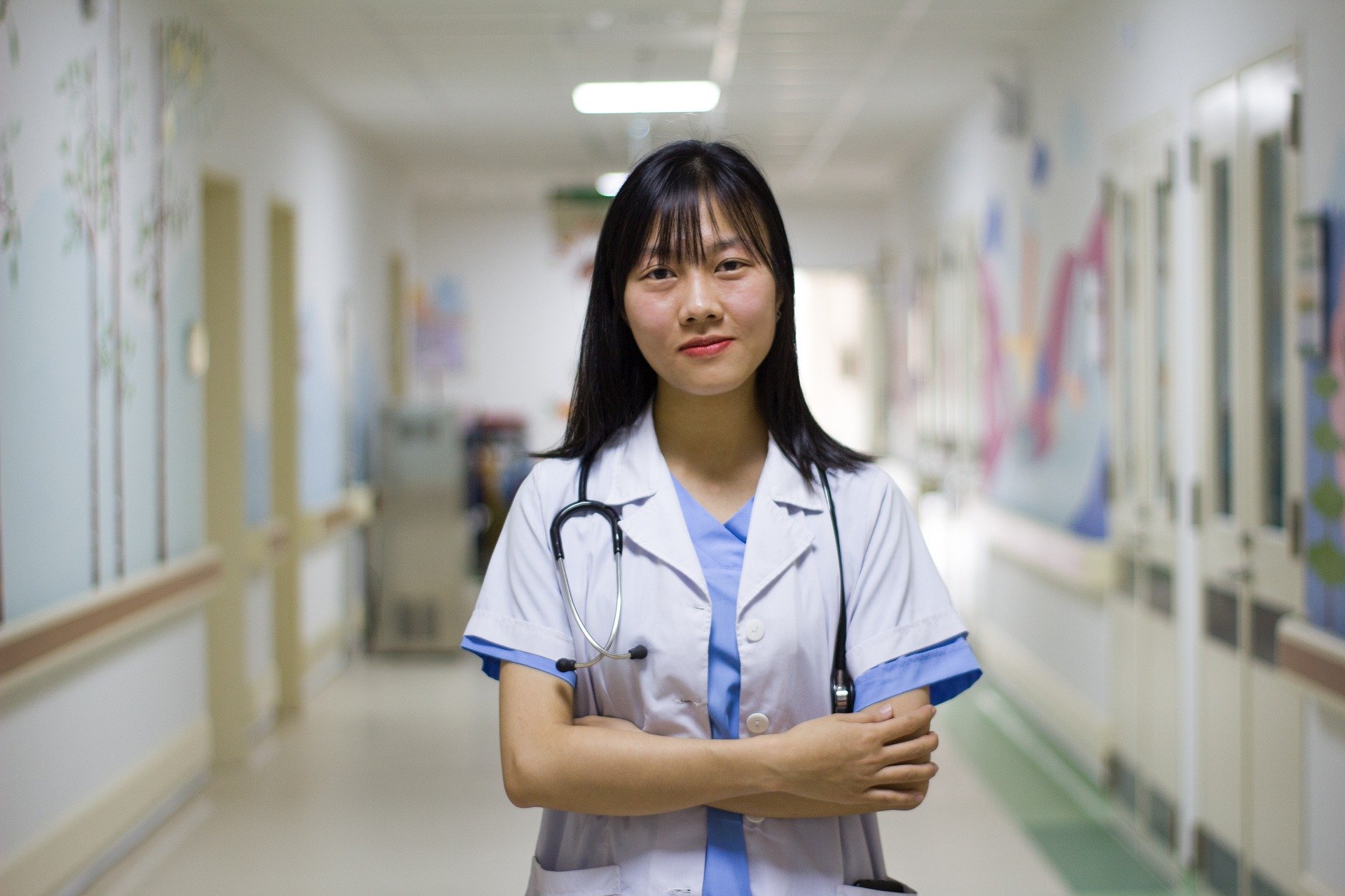 Doctora sonriente en pasillo de hospital. │Foto: Pixabay