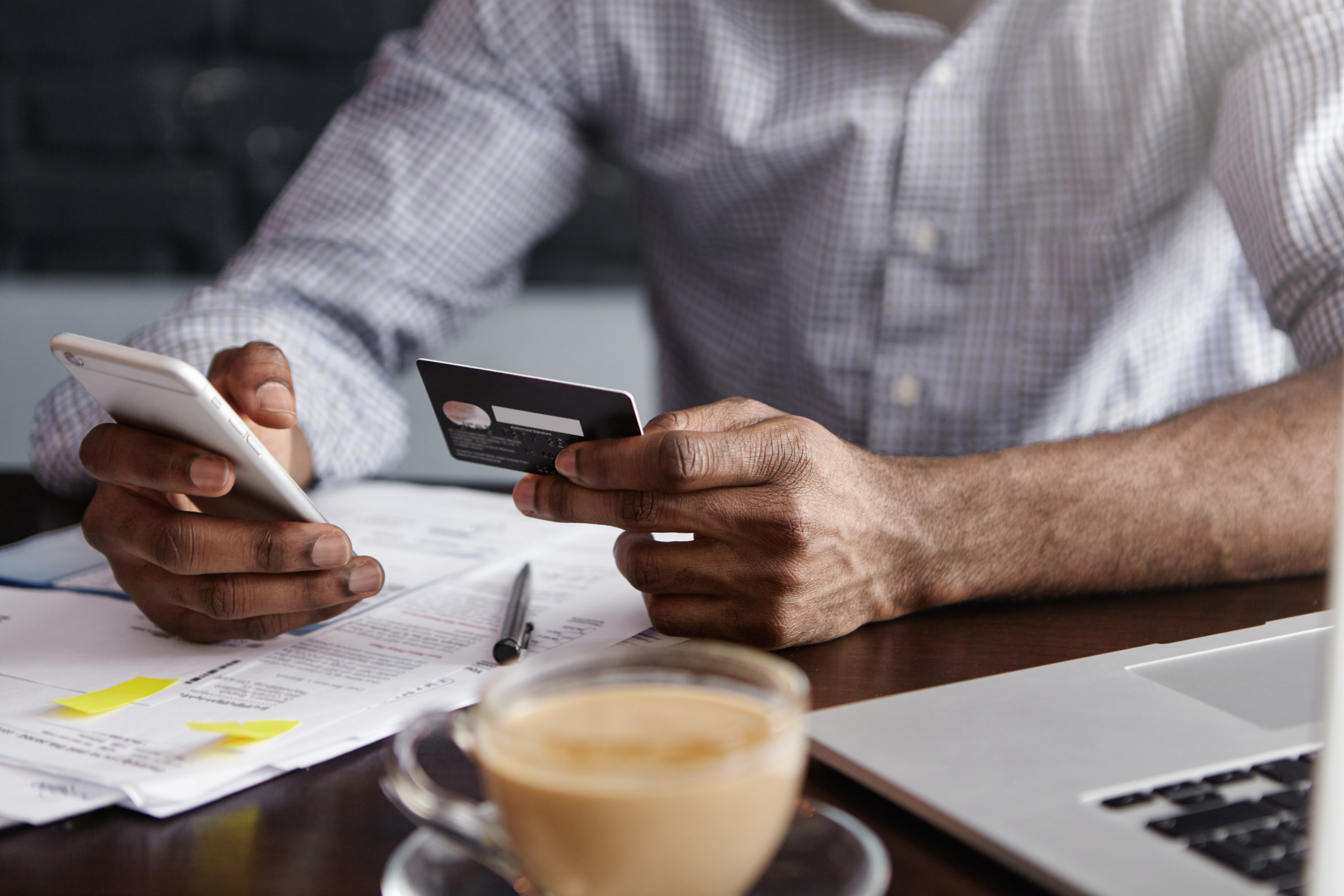 Un hombre con una tarjeta bancaria y un teléfono | Fuente: Shutterstock