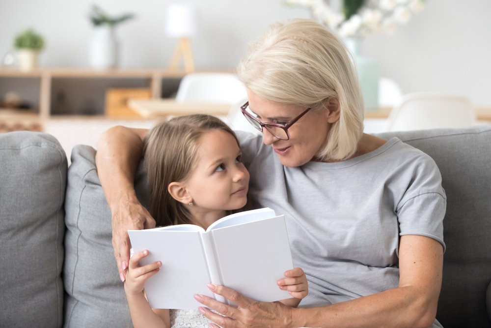 Abuela amorosa leyendo un cuento de hadas a su nieta. | Fuente: Shutterstock