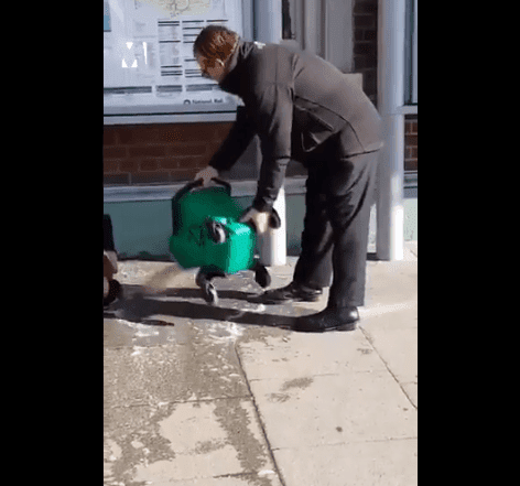 Trabajador vertiendo agua sucia sobre hombre. | Imagen: Twitter / Metro UK