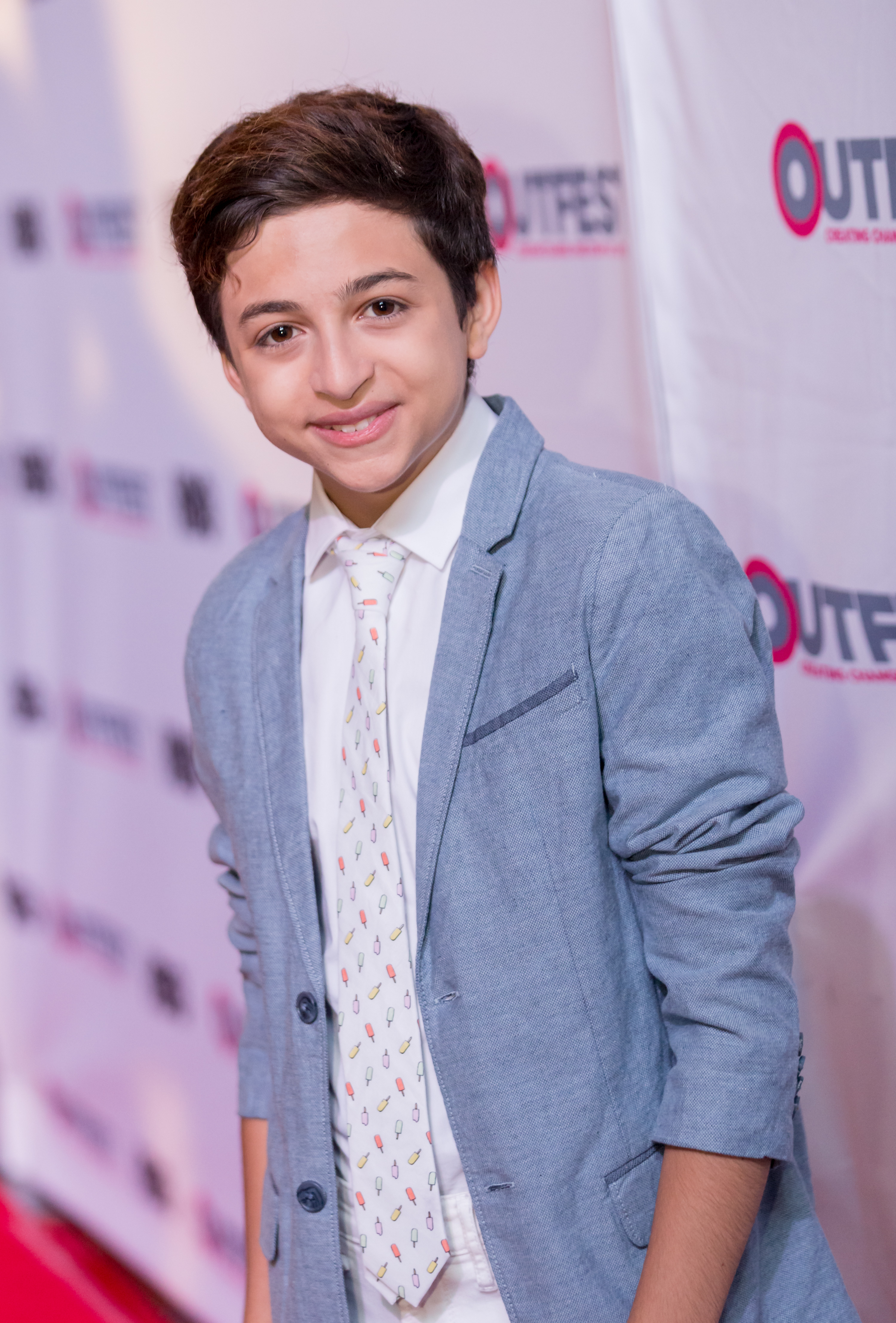 J.J. Totah asiste a la gala de clausura de "Other People" en el Outfest de Los Ángeles, en Los Ángeles (California), vestido con una chaqueta azul claro, una camisa blanca y una corbata estampada. | Fuente: Getty Images