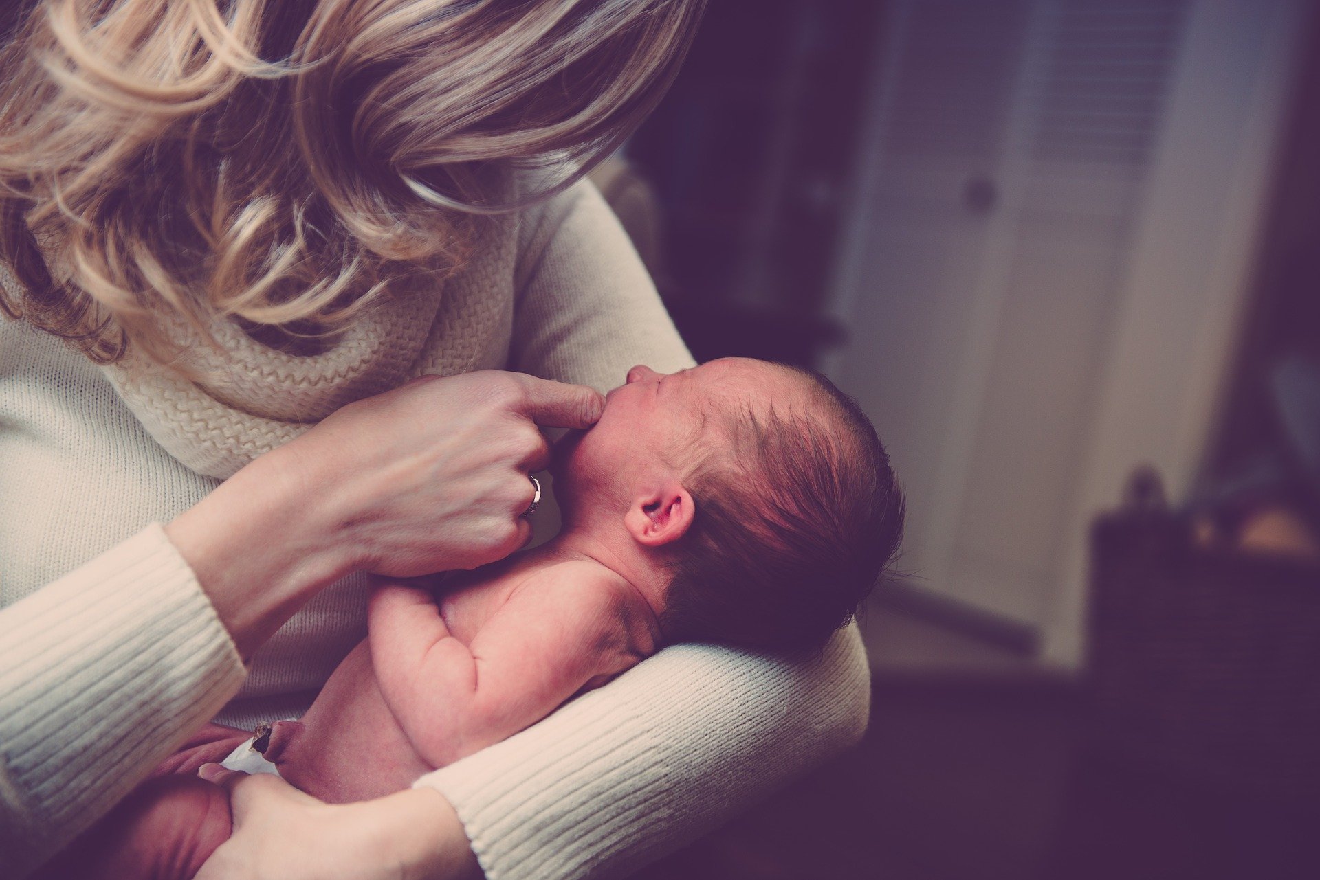 Bebé en brazos de una mujer. │Foto: Pixabay
