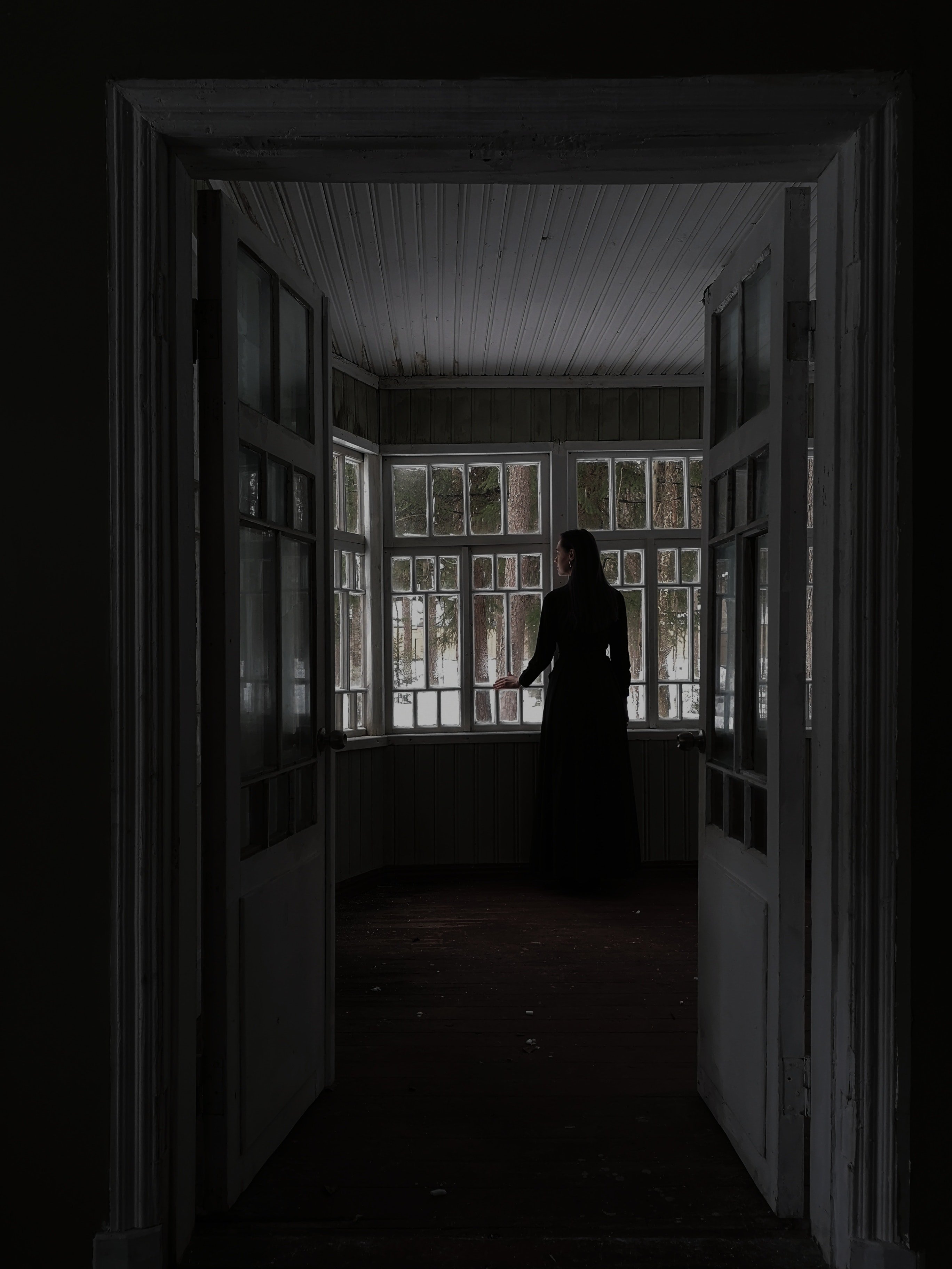 Mujer viendo por una ventana. | Foto: Pexels