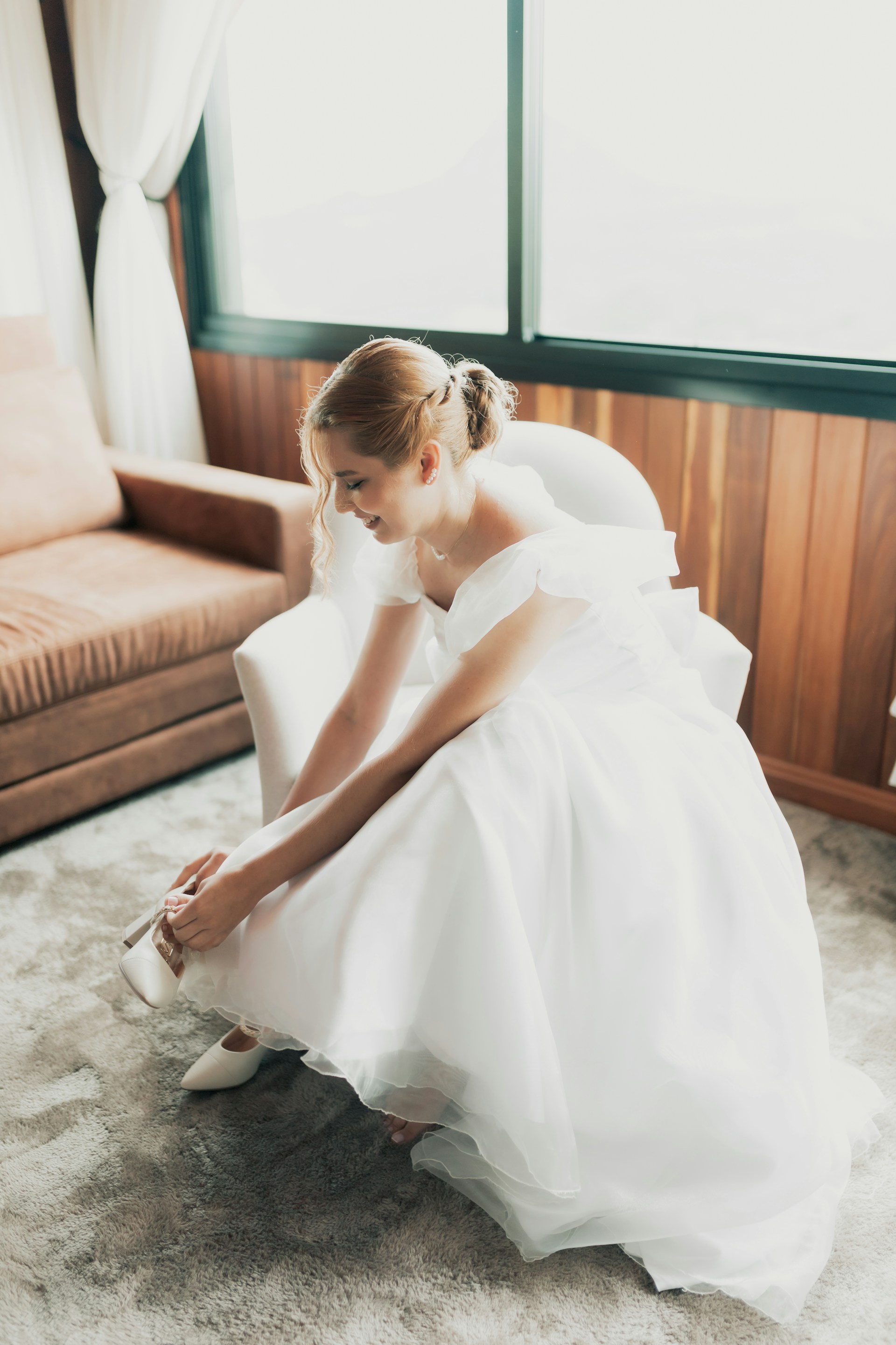 Una novia riendo mientras arregla su zapato | Fuente: Unsplash