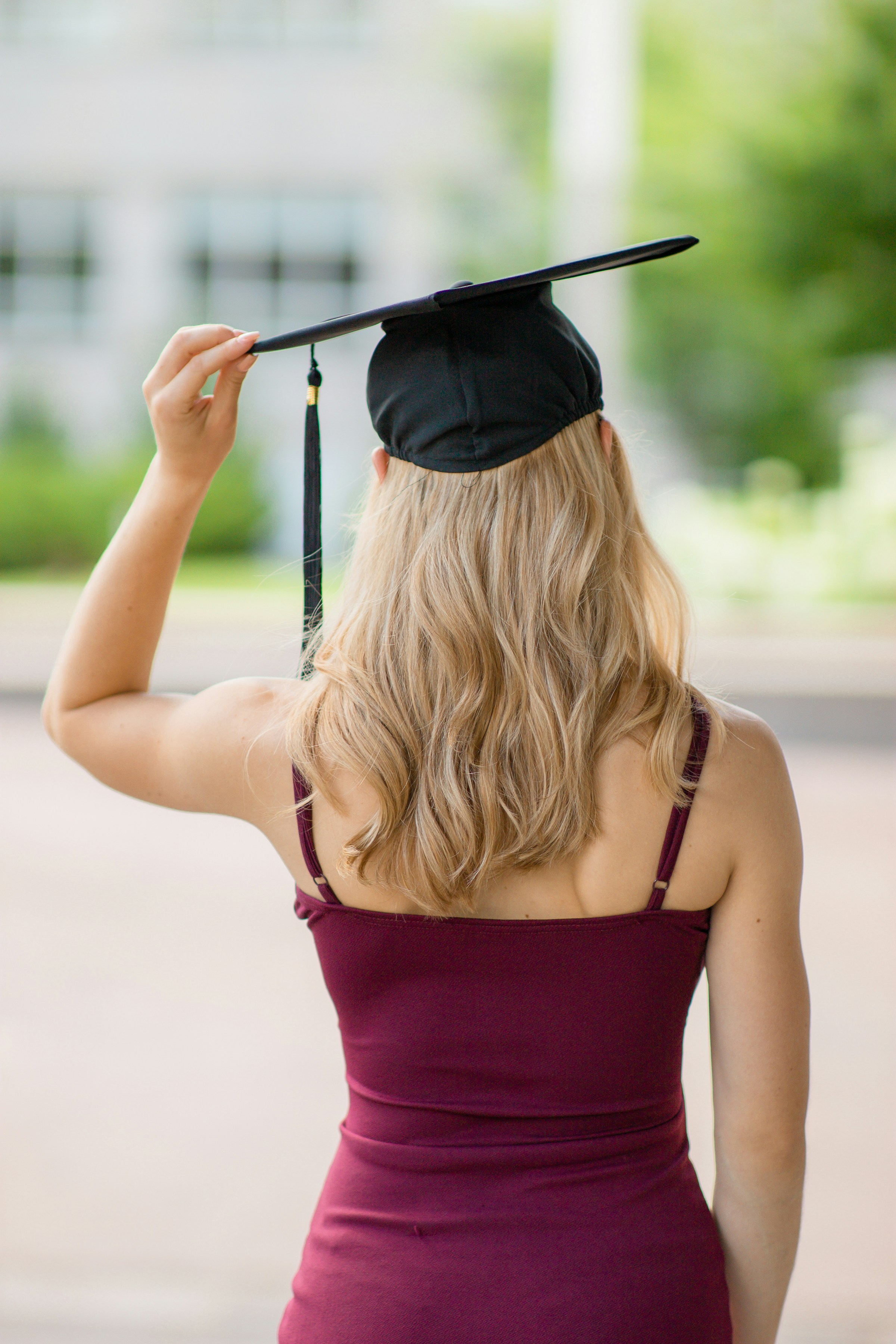 Una mujer joven sujetando un birrete sobre su cabeza | Fuente: Unsplash