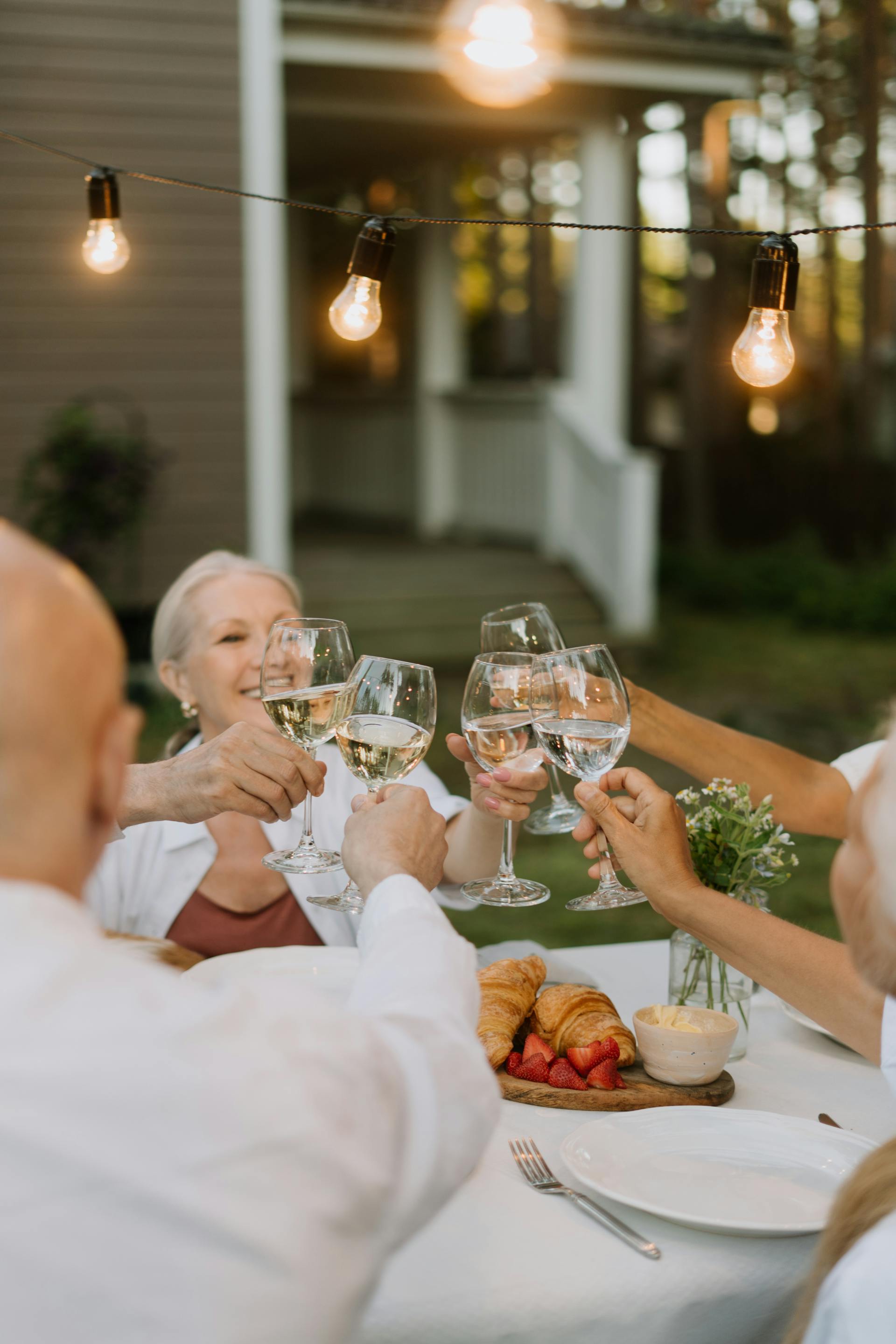 Miembros de la familia levantando sus copas durante la cena | Fuente: Pexels