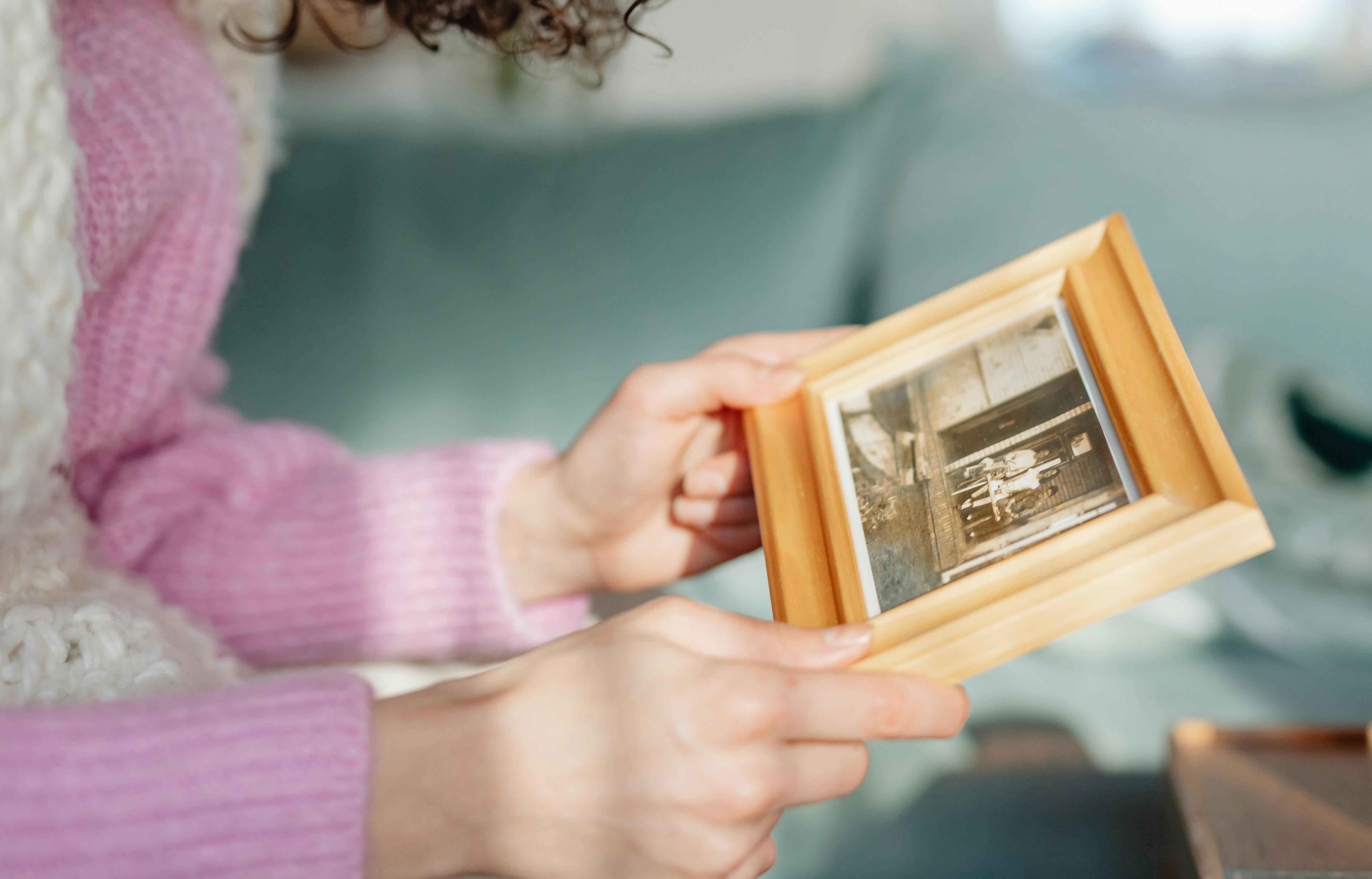 Una mujer sujetando un marco de fotos | Fuente: Pexels