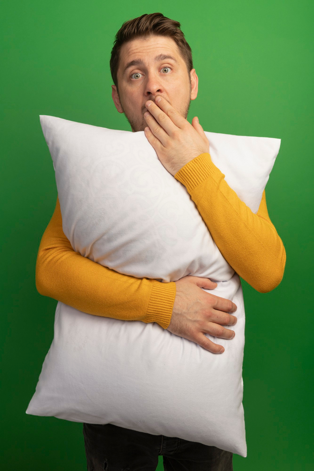 Un hombre aturdido sujetando una almohada | Fuente: Freepik