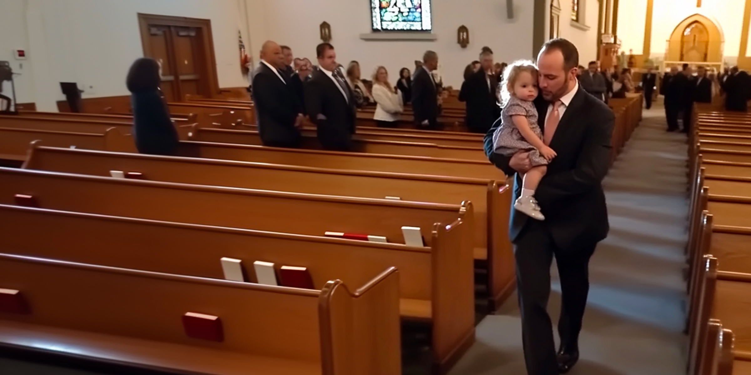 Hombre caminando en una iglesia con una niña en brazos | Fuente: Amomama