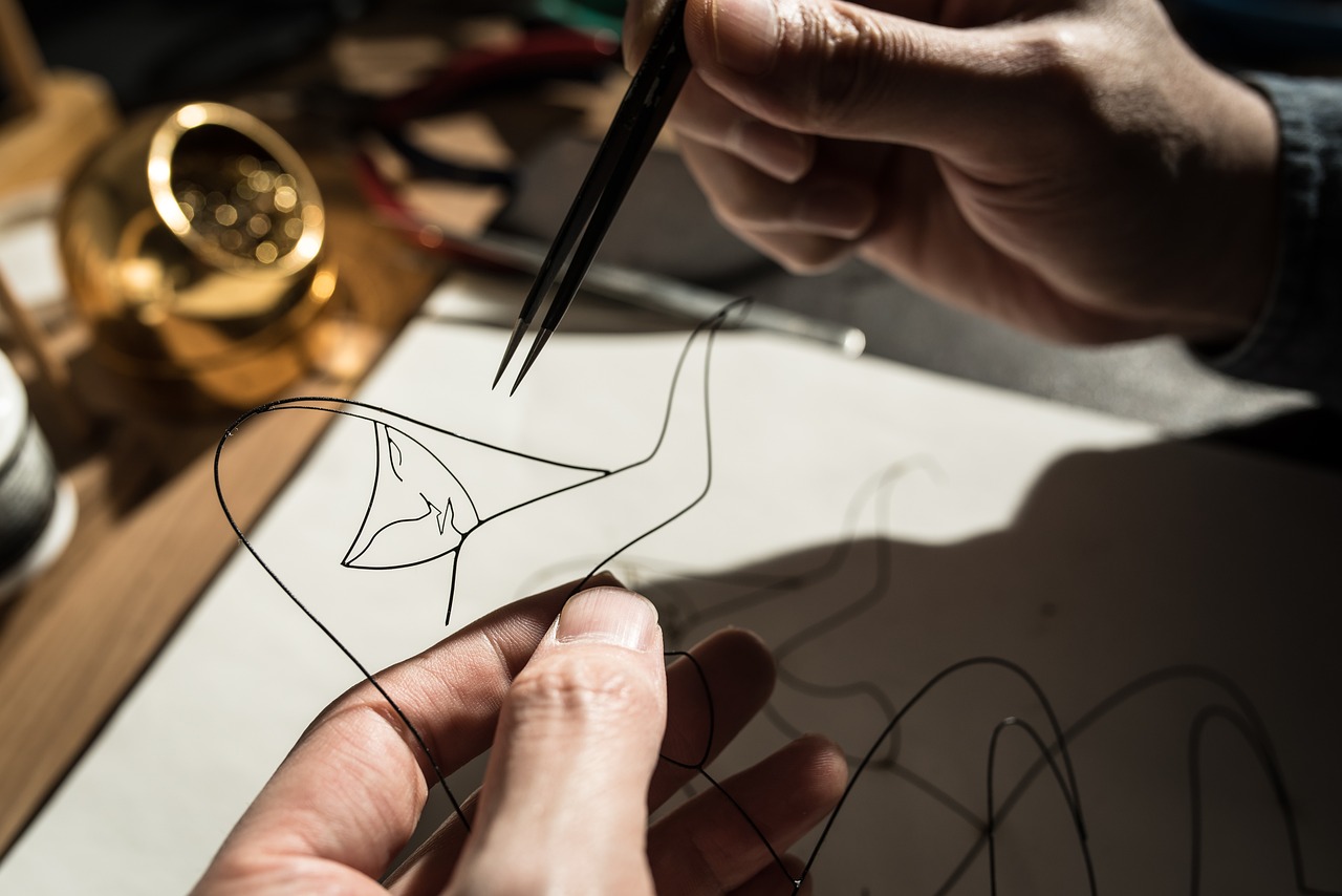 Una persona haciendo una escultura de alambre de una mujer | Fuente: Pixabay