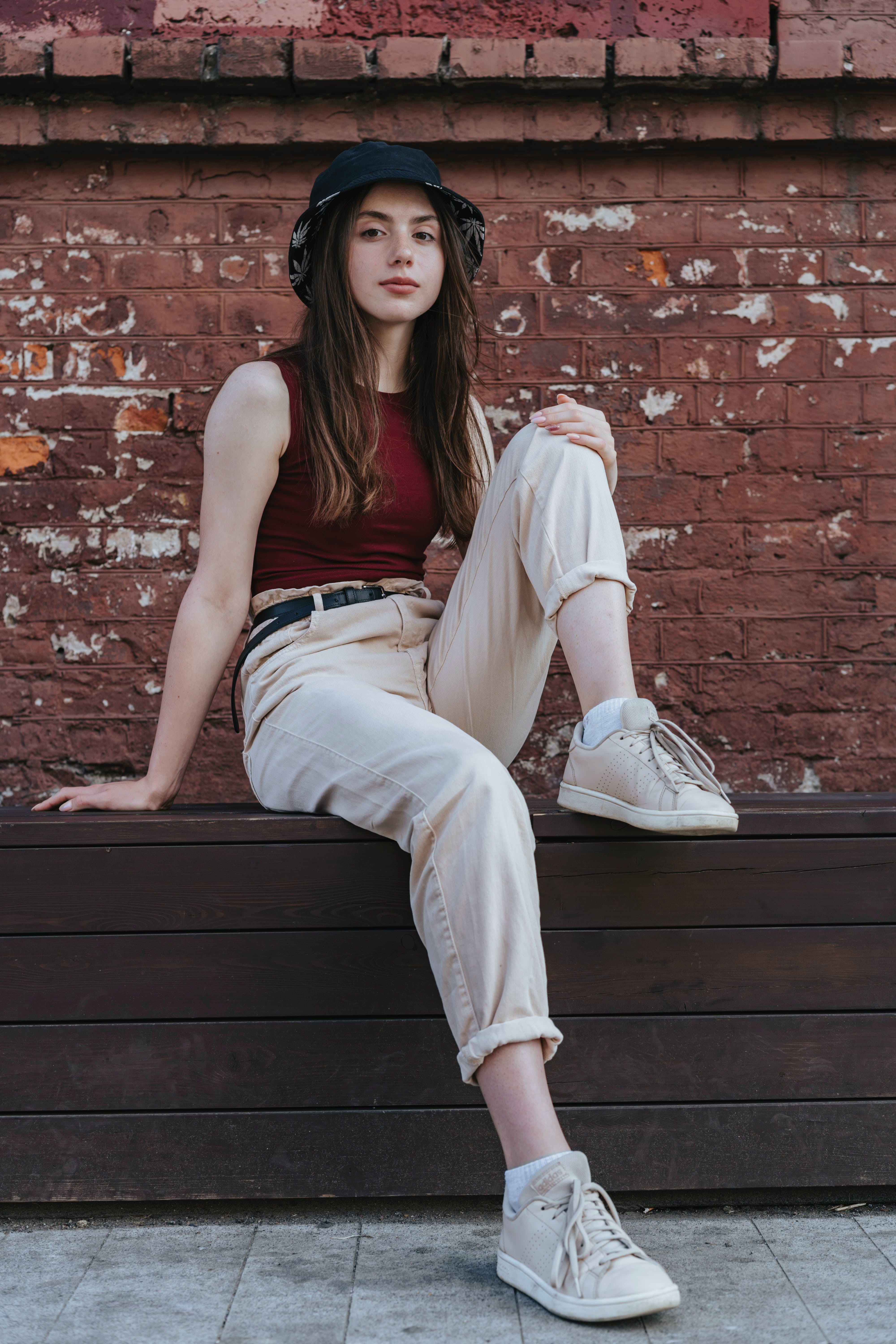 Una joven sentada en una pared | Foto: Pexels