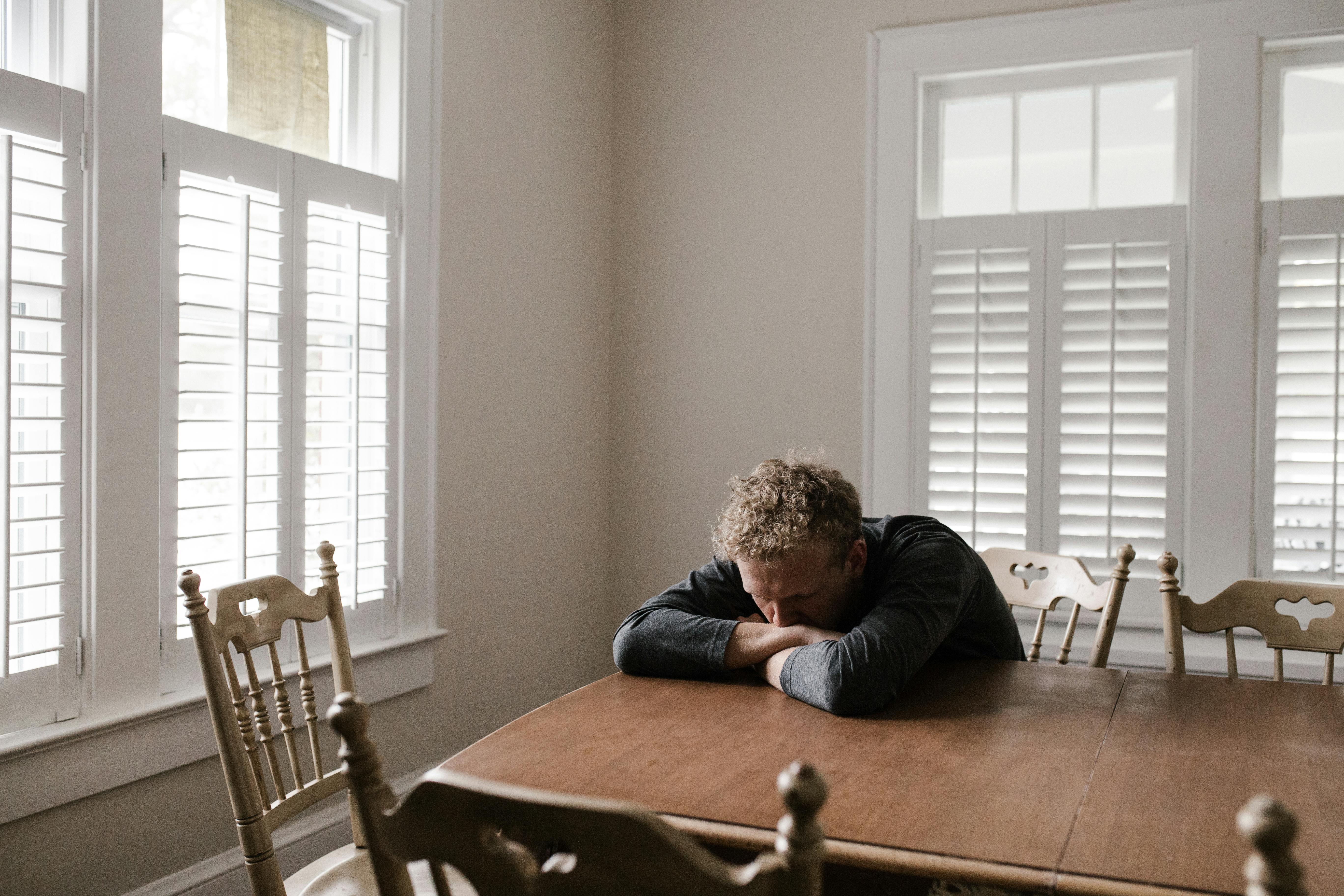 Un hombre solitario tumbado sobre una mesa | Fuente: Pexels