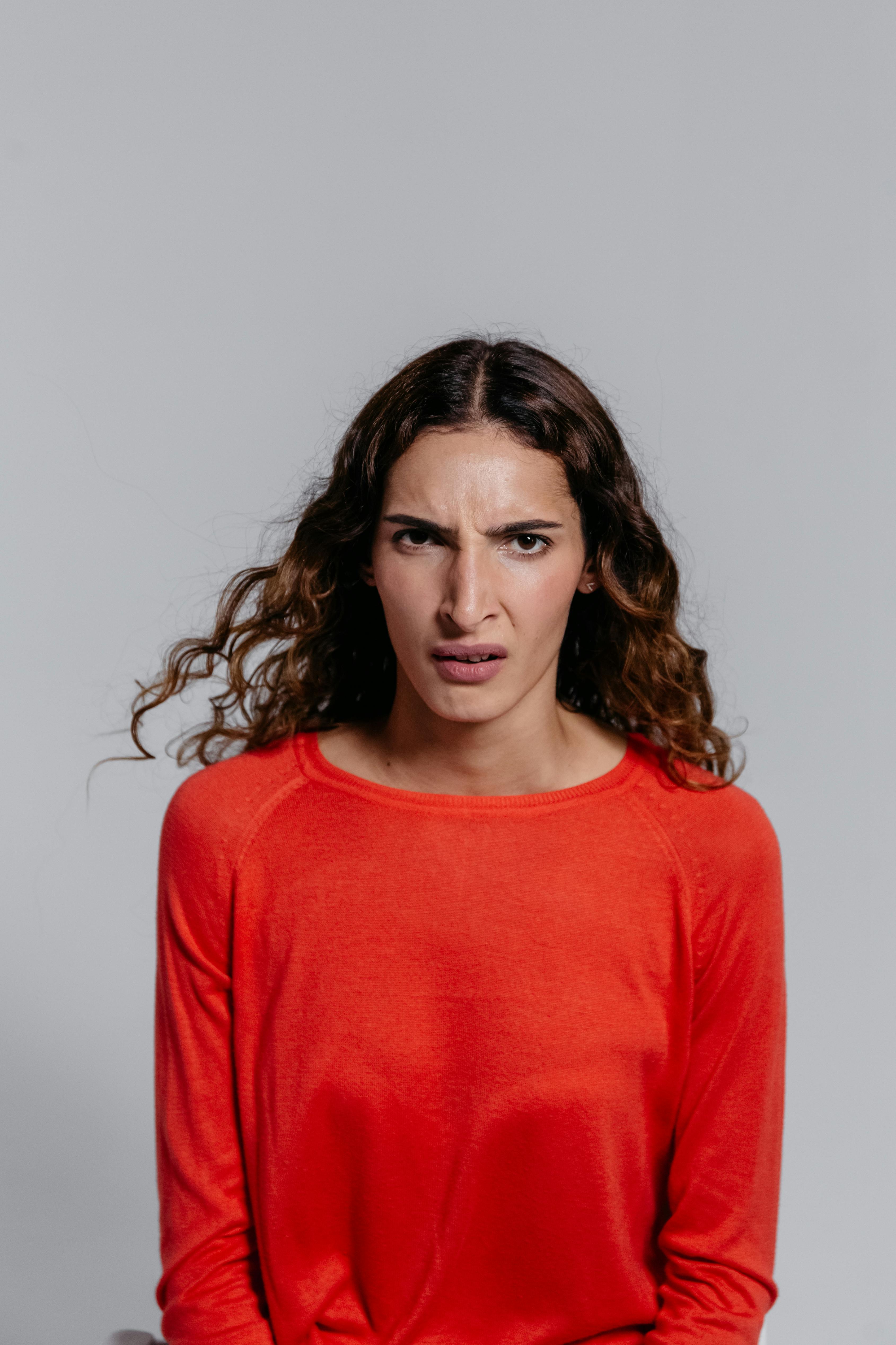 Una donna arrabbiata con un maglione rosso | Fonte: Pexels
