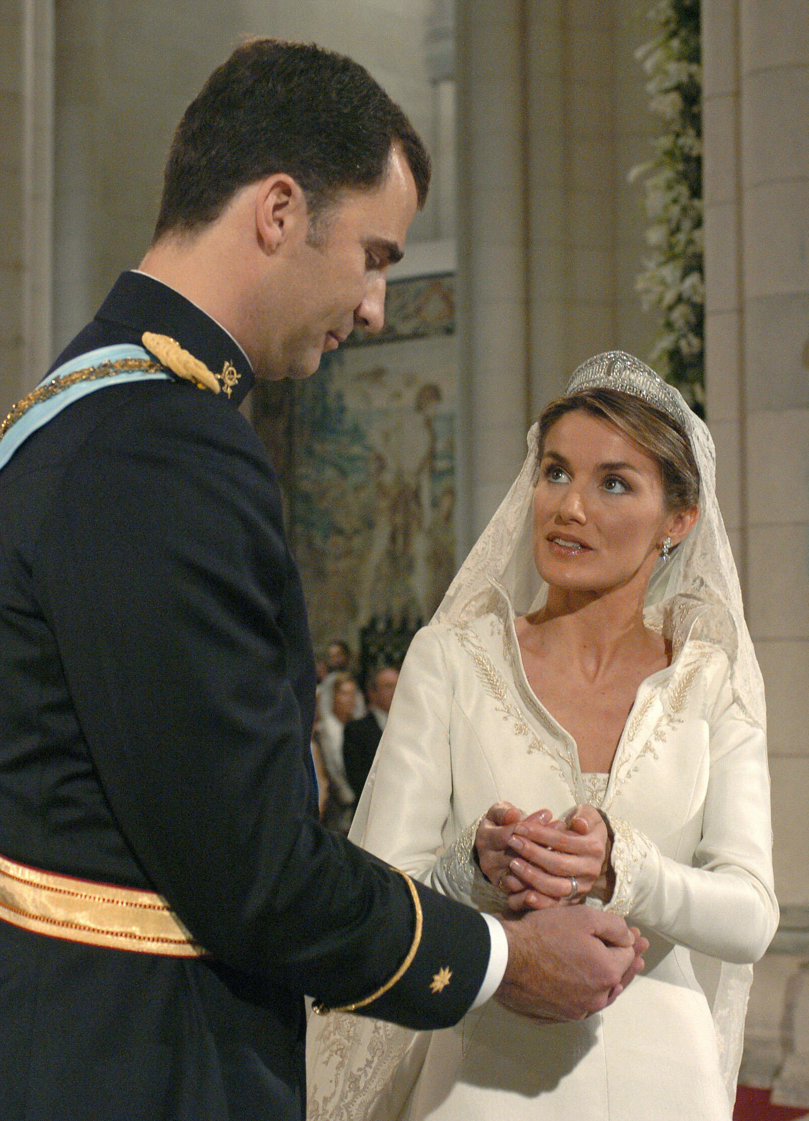 Letizia Ortiz coloca el anillo en el dedo del príncipe heredero español Felipe de Borbón durante su ceremonia de boda en la catedral de la Almudena de Madrid el 22 de mayo de 2004. | Fuente: Getty Images