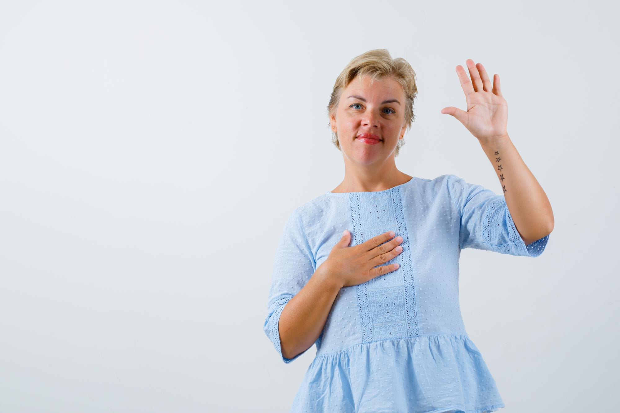 Una mujer levanta la mano para objetar algo | Foto: Freepik