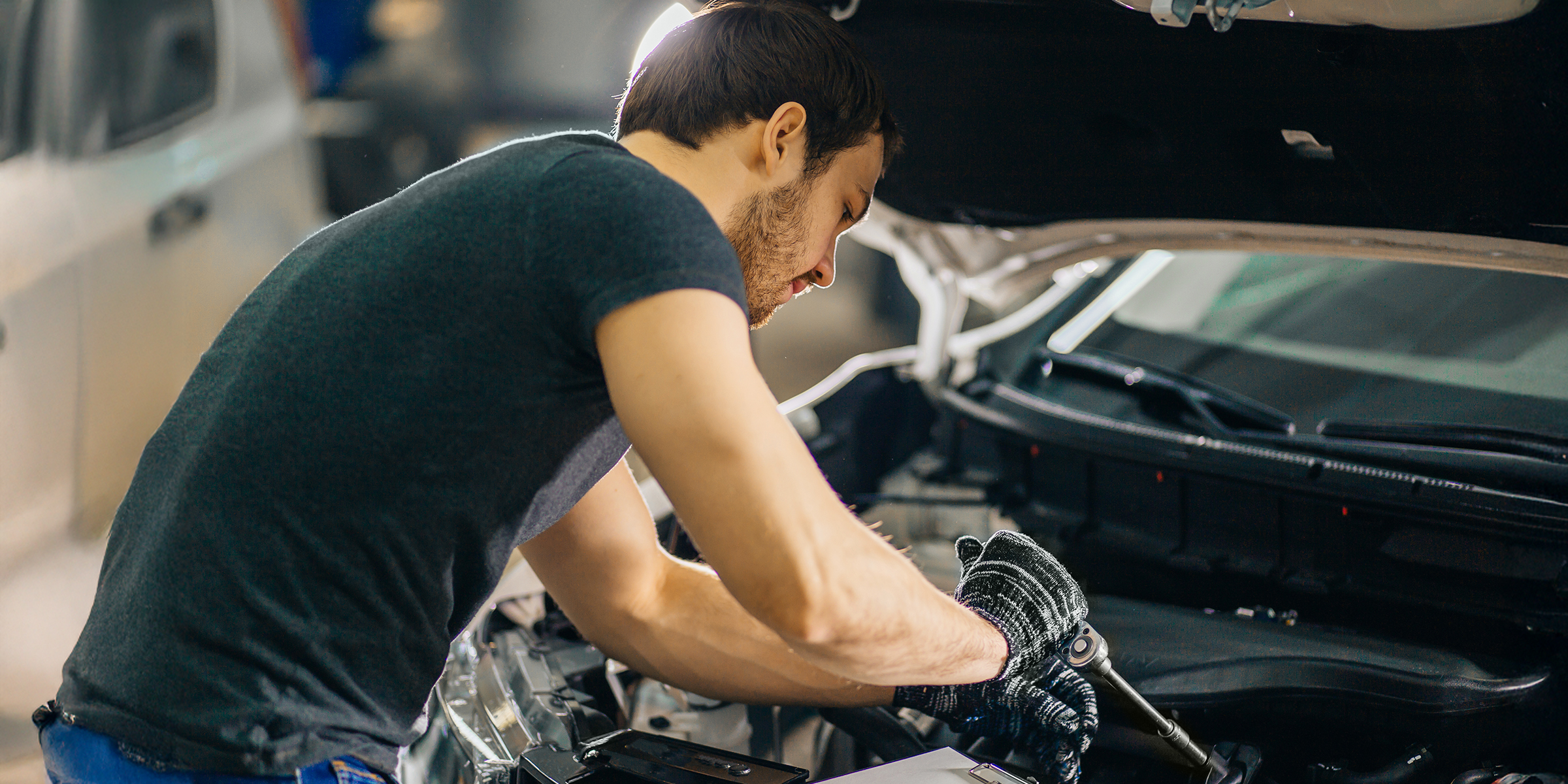 Hombre arreglando un Automóvil | Fuente: Shutterstock