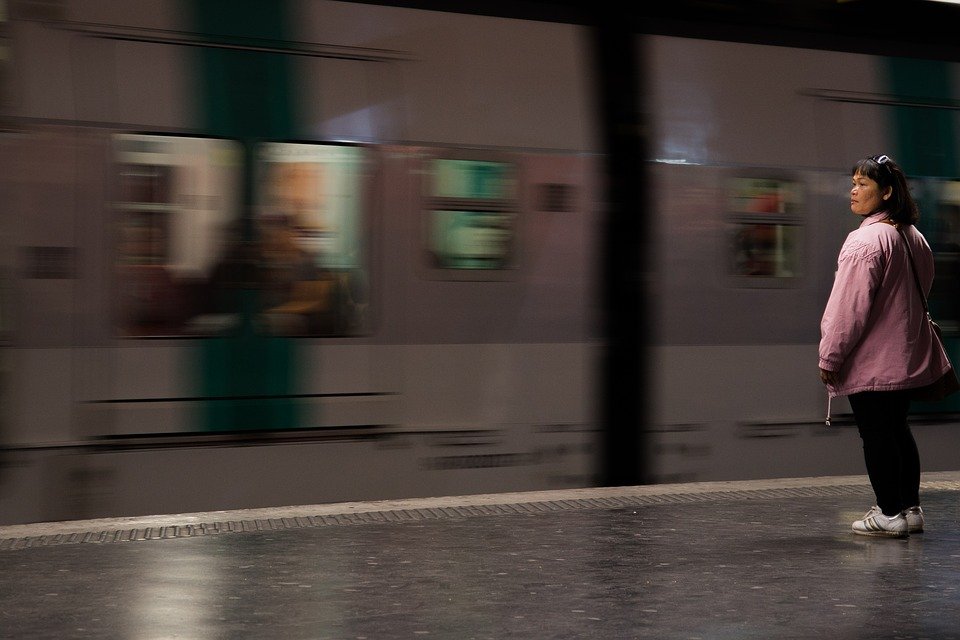 Mujer parada en plataforma frente al metro. | Imagen: Pixabay