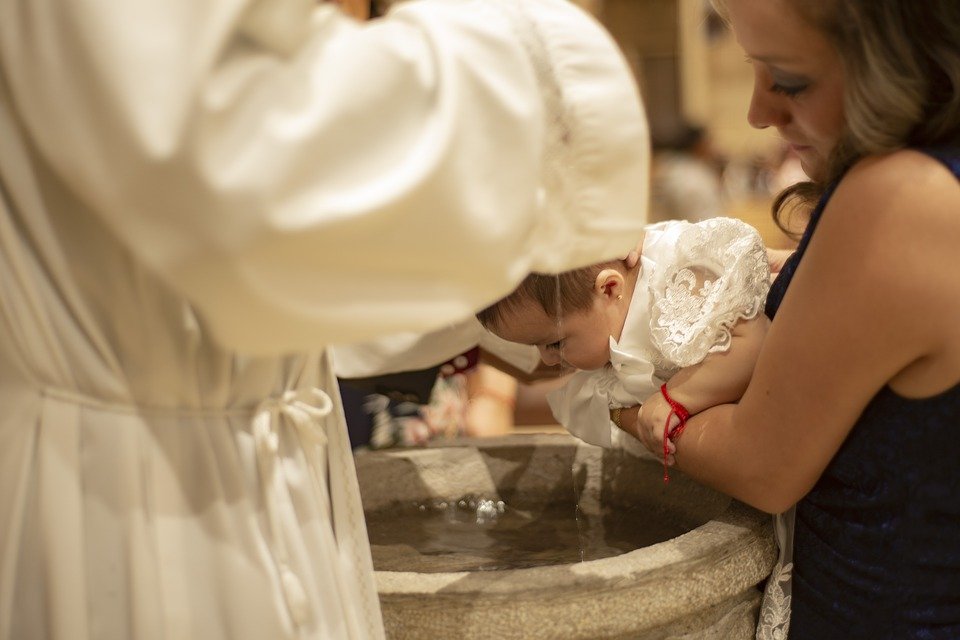 Cura bautizando a un bebé.| Imagen: Pixabay
