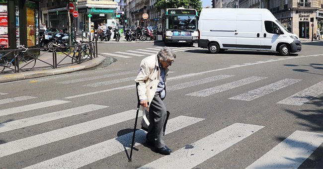 Mujer mayor cruzando la calle con un bastón en su mano. | Imagen: Shutterstock
