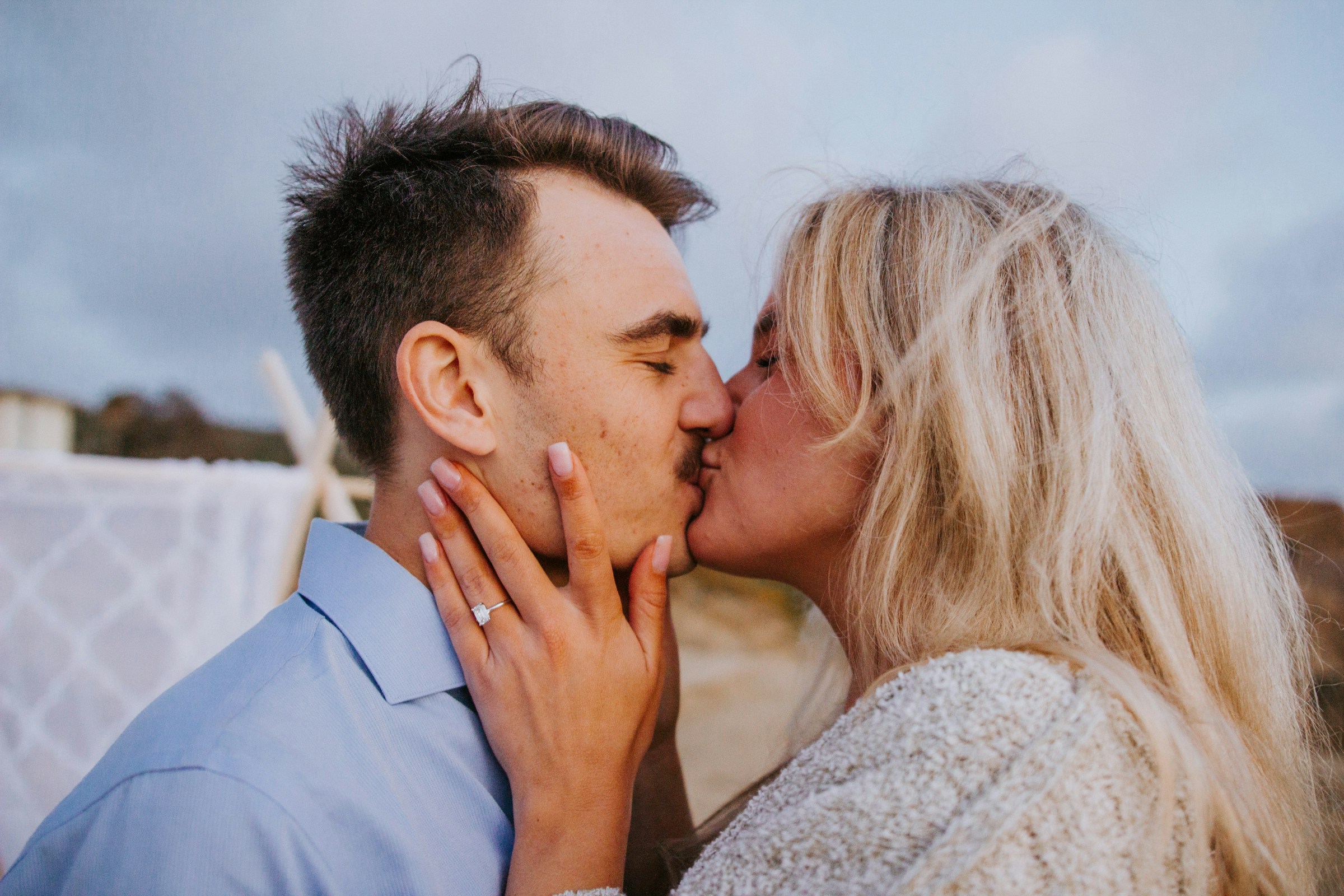 Una pareja besándose mientras muestra su anillo de compromiso | Fuente: Unsplash