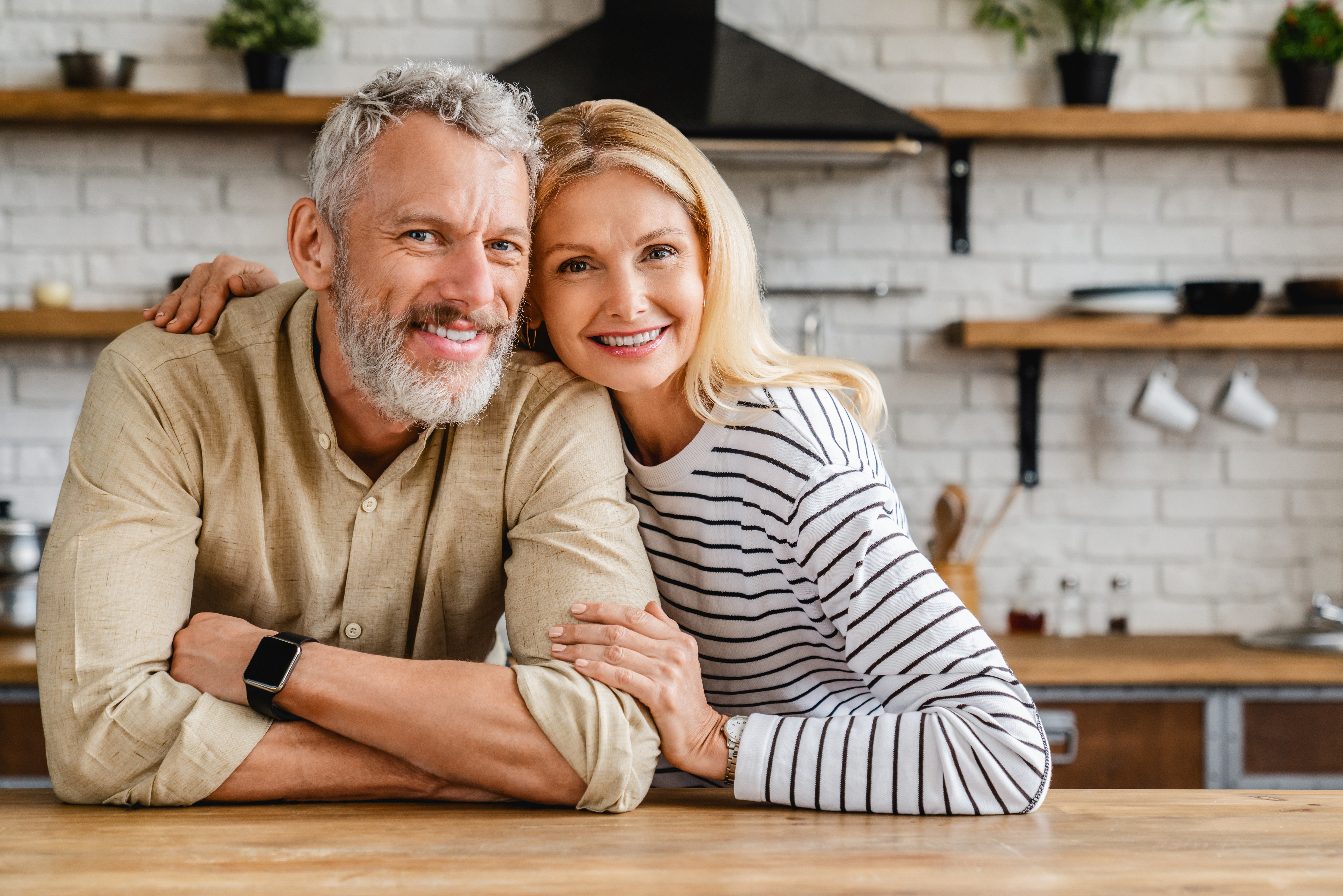 Una pareja de mediana edad abrazándose en la cocina. | Foto: Shutterstock