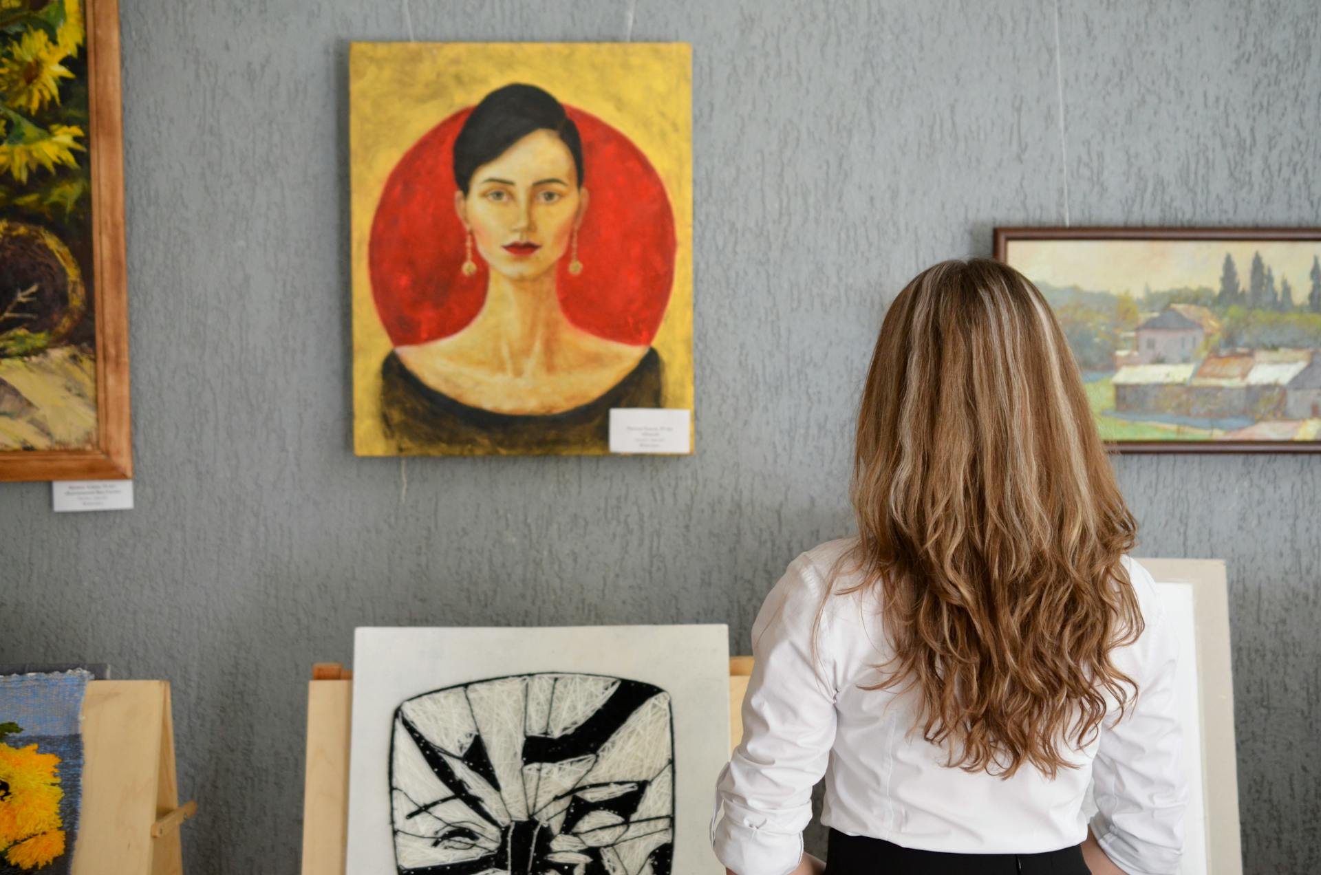 Vista trasera de una mujer mirando un cuadro expuesto en una pared | Fuente: Pexels