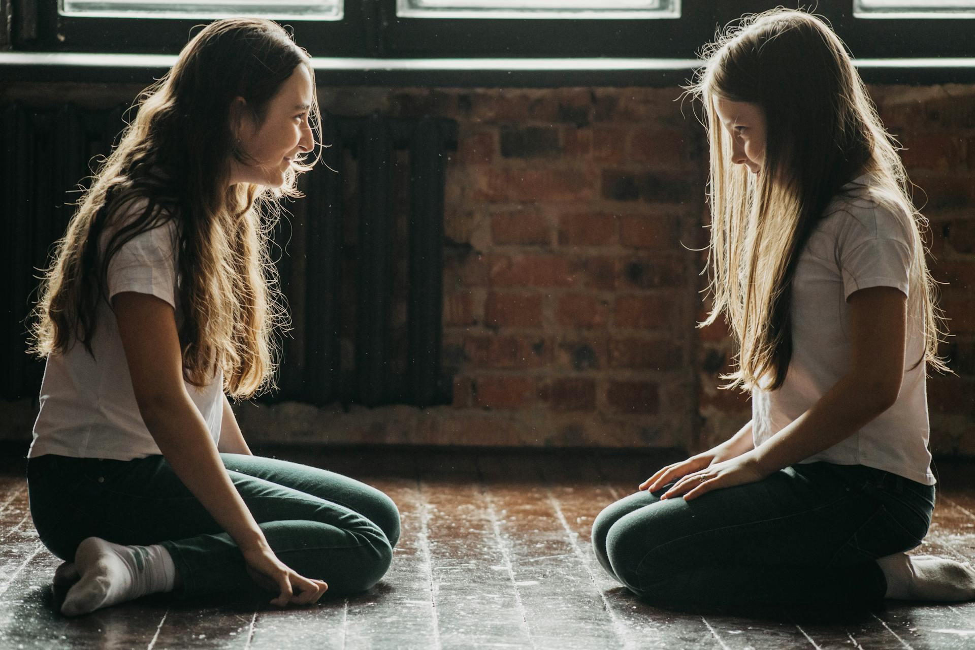 Dos chicas jóvenes sentadas en el suelo una frente a la otra | Fuente: Pexels