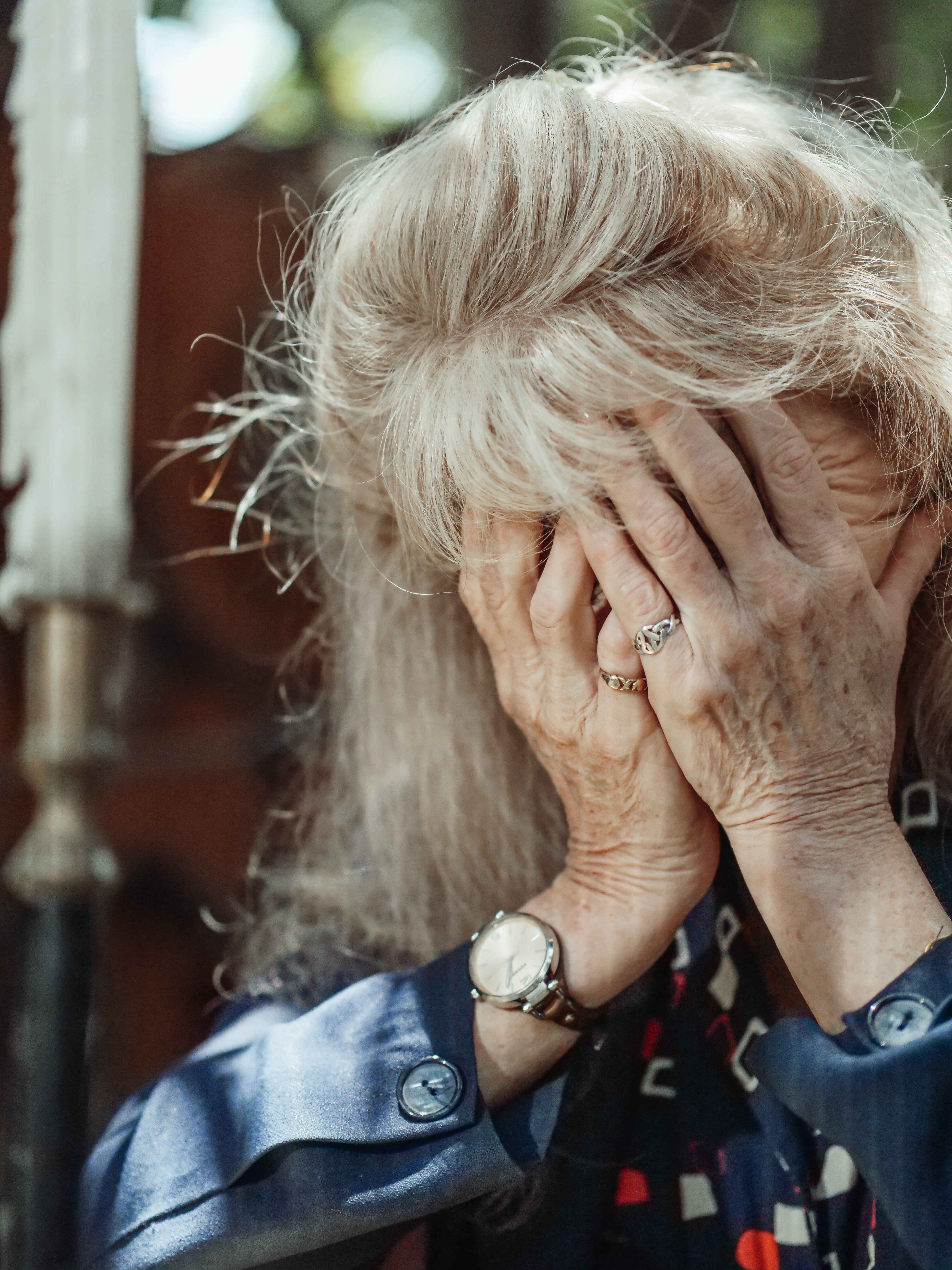 Una anciana llora con su rostro entre sus manos. | Foto: Pexels