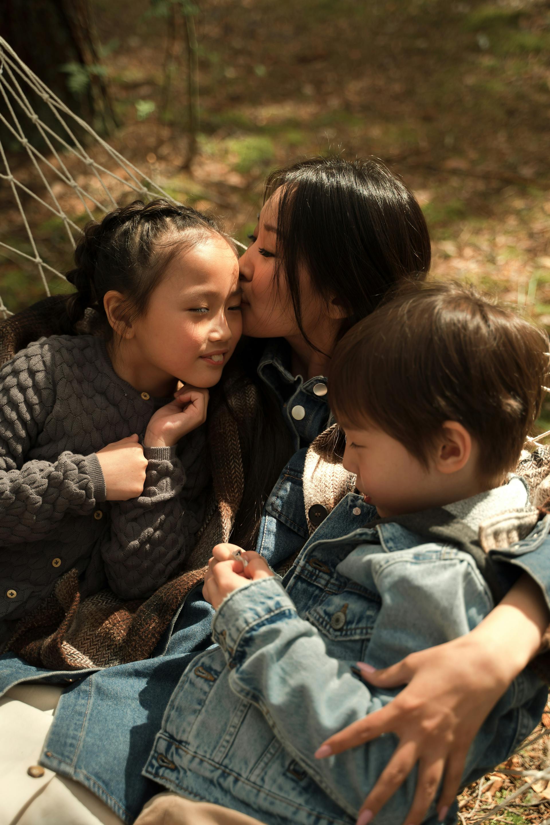 Una mujer besando a sus hijos | Fuente: Pexels