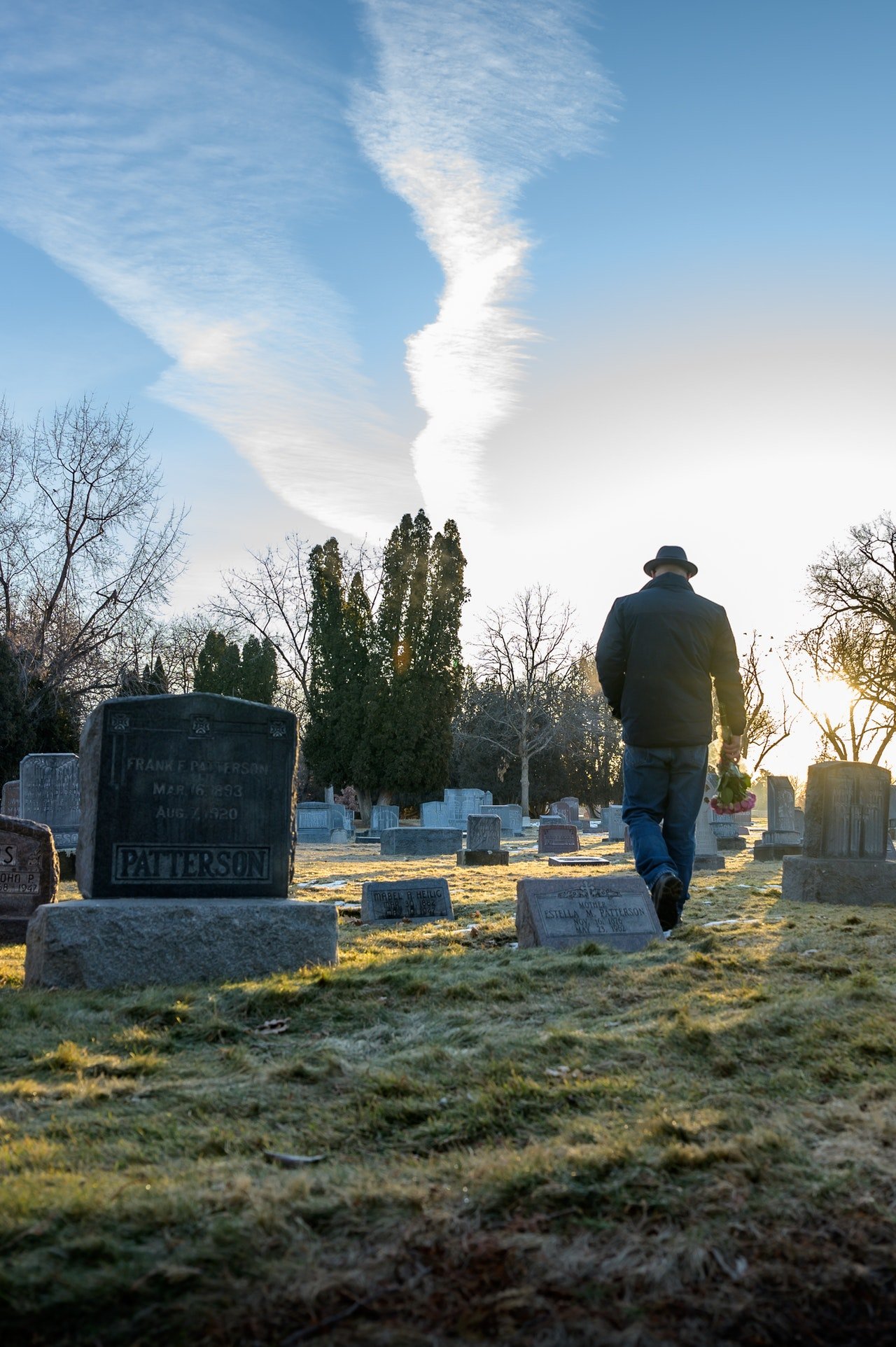 Un hombre con sombrero lleva una flores al cementerio. | Foto: Pexels