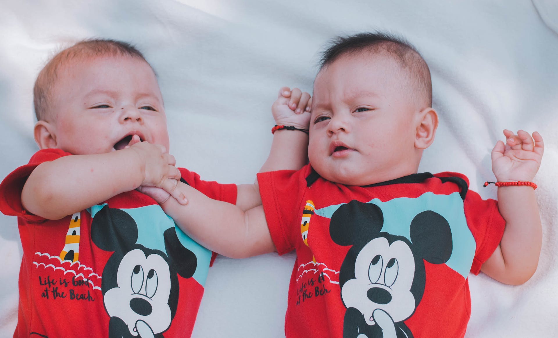 Dos bebés con camisetas rojas de Mickey Mouse | Foto: Pexels