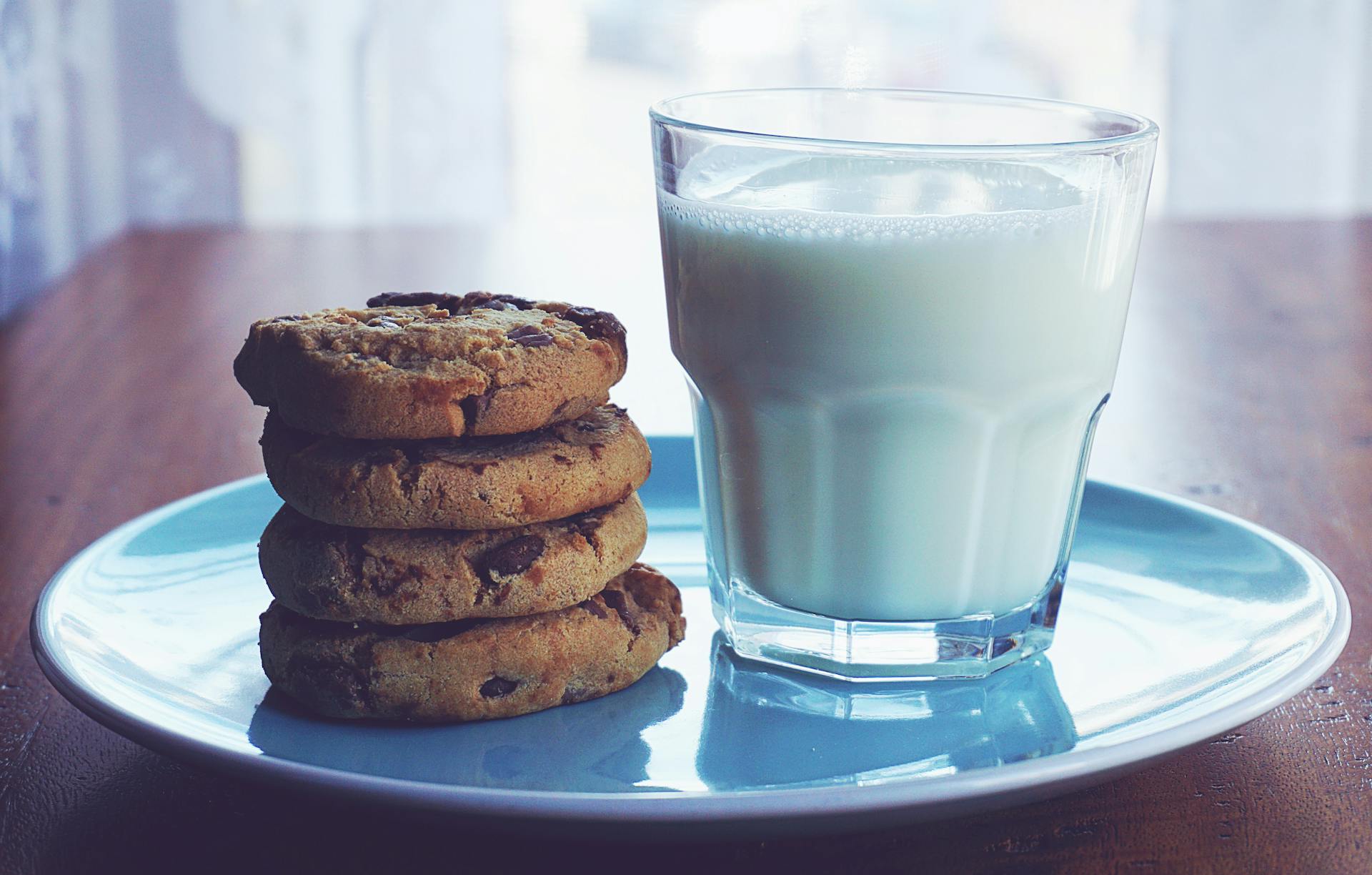 Galletas de chocolate y un vaso de leche | Fuente: Midjourney