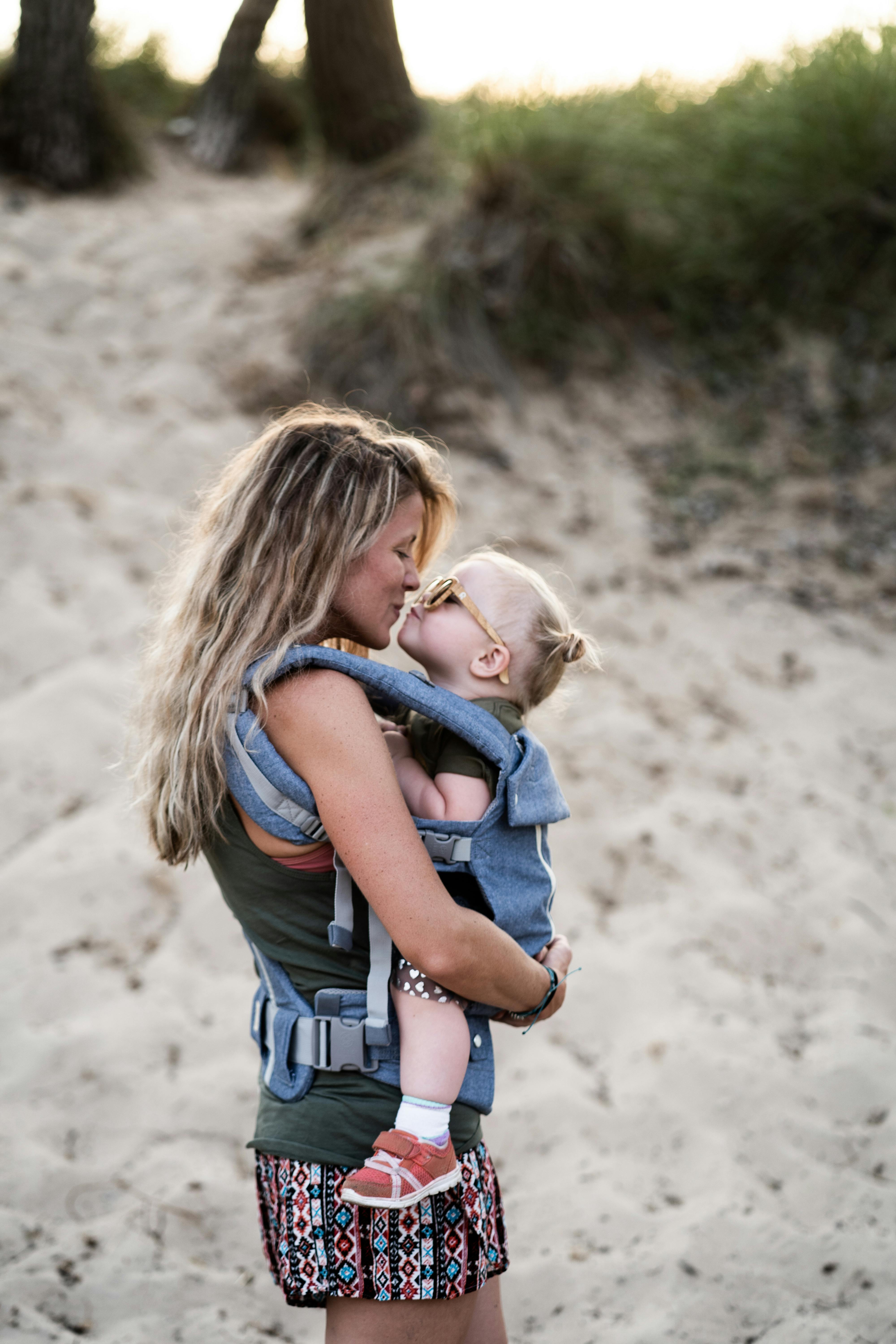 Una mujer a punto de compartir un beso con un niño en la playa | Fuente: Pexels