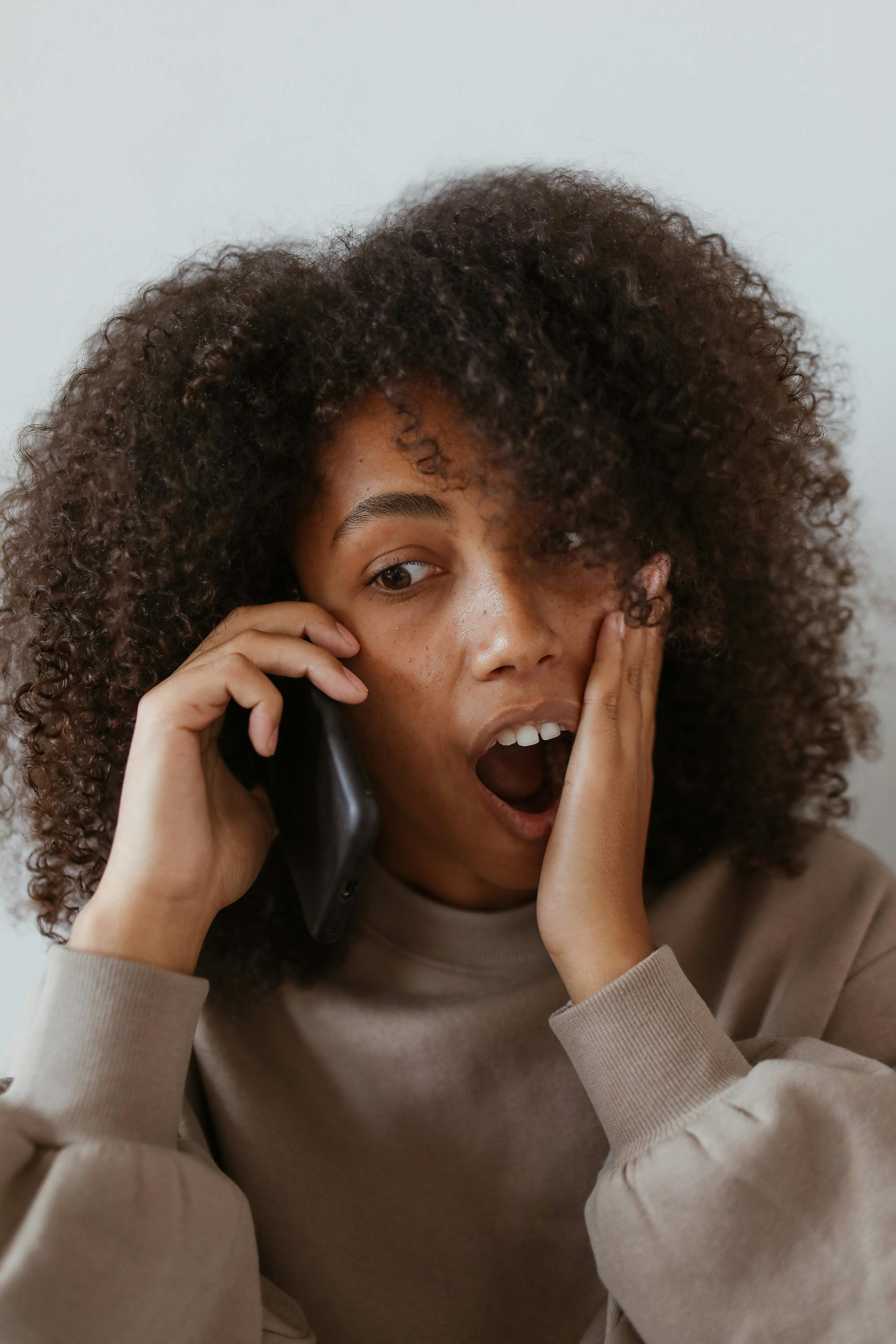 Una mujer reacciona en estado de shock mientras habla por teléfono | Fuente: Pexels